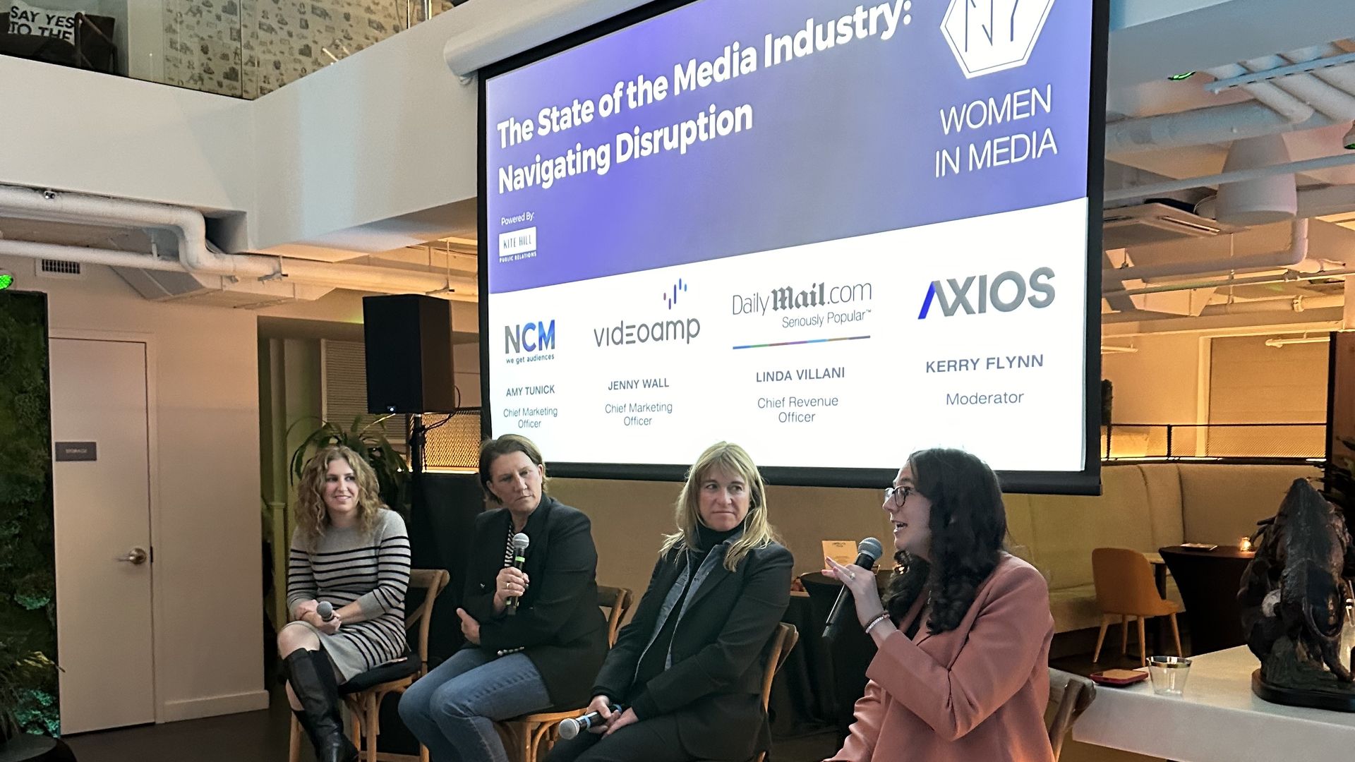 Four women sitting in chairs in front of a screen that reads "The State of the Media Industry: Navigating Disruption"