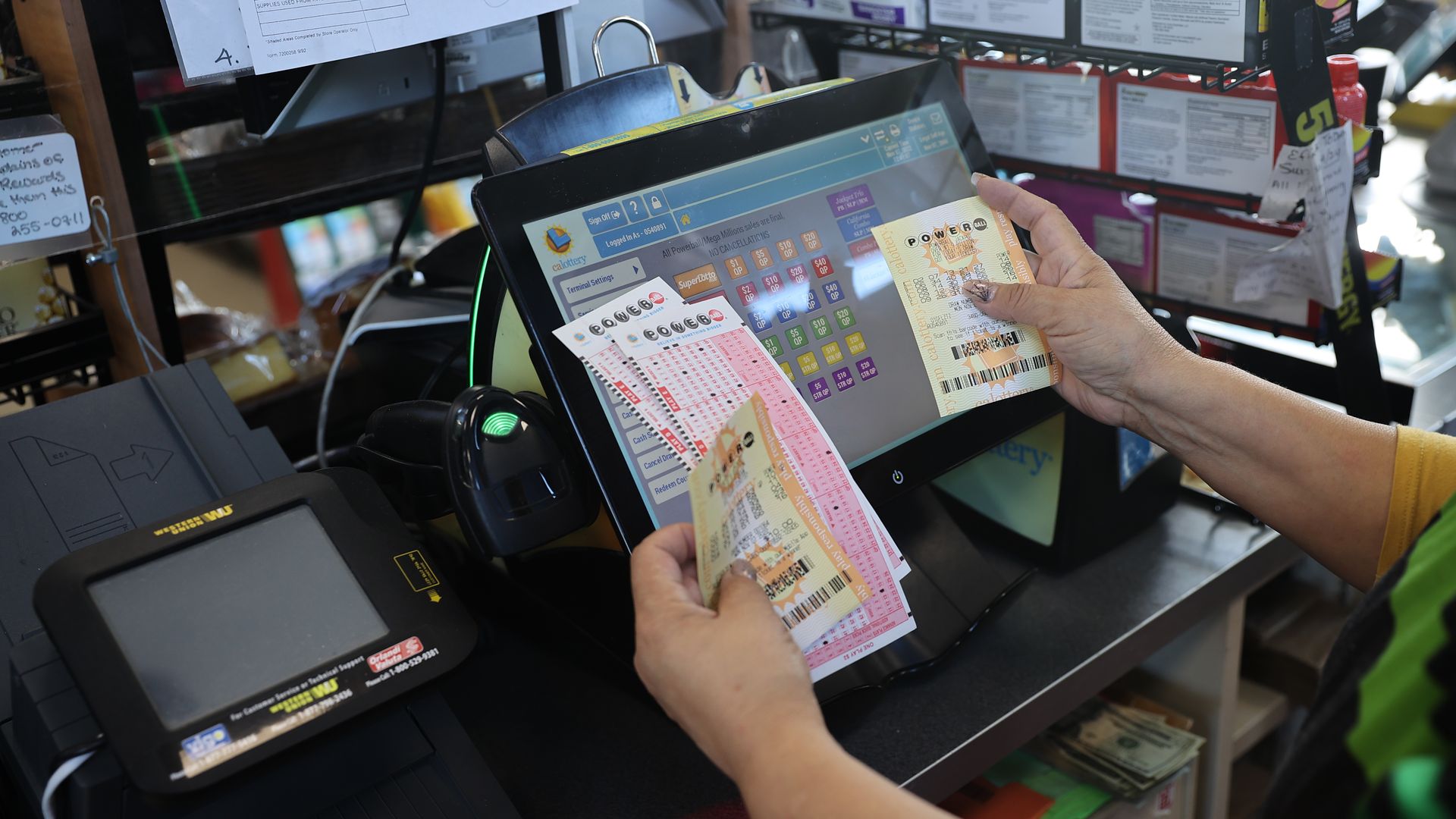 A cashier holds Powerball lottery tickets