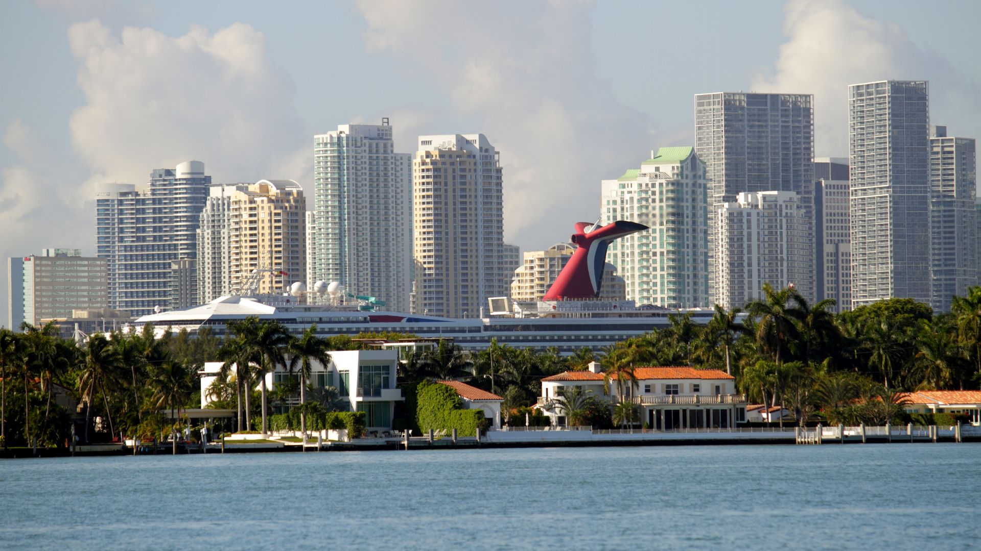 A cruise ship with the Miami skyline in the background. 