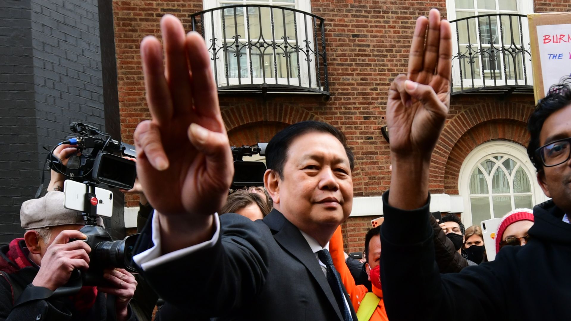 Photo of Kyaw Zwar Minn raising three fingers to the camera