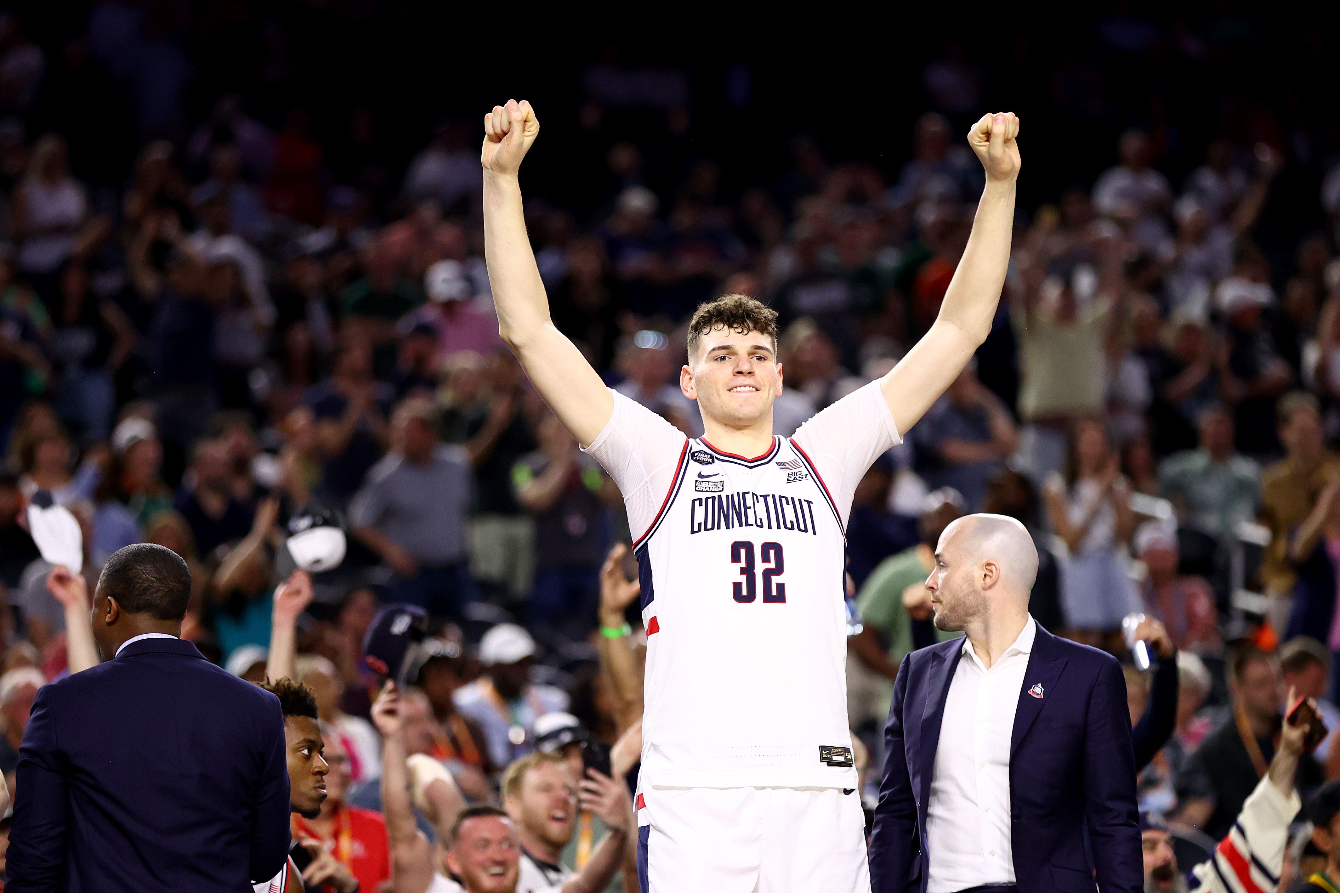 Photo of a basketball player raising his arms in triumph