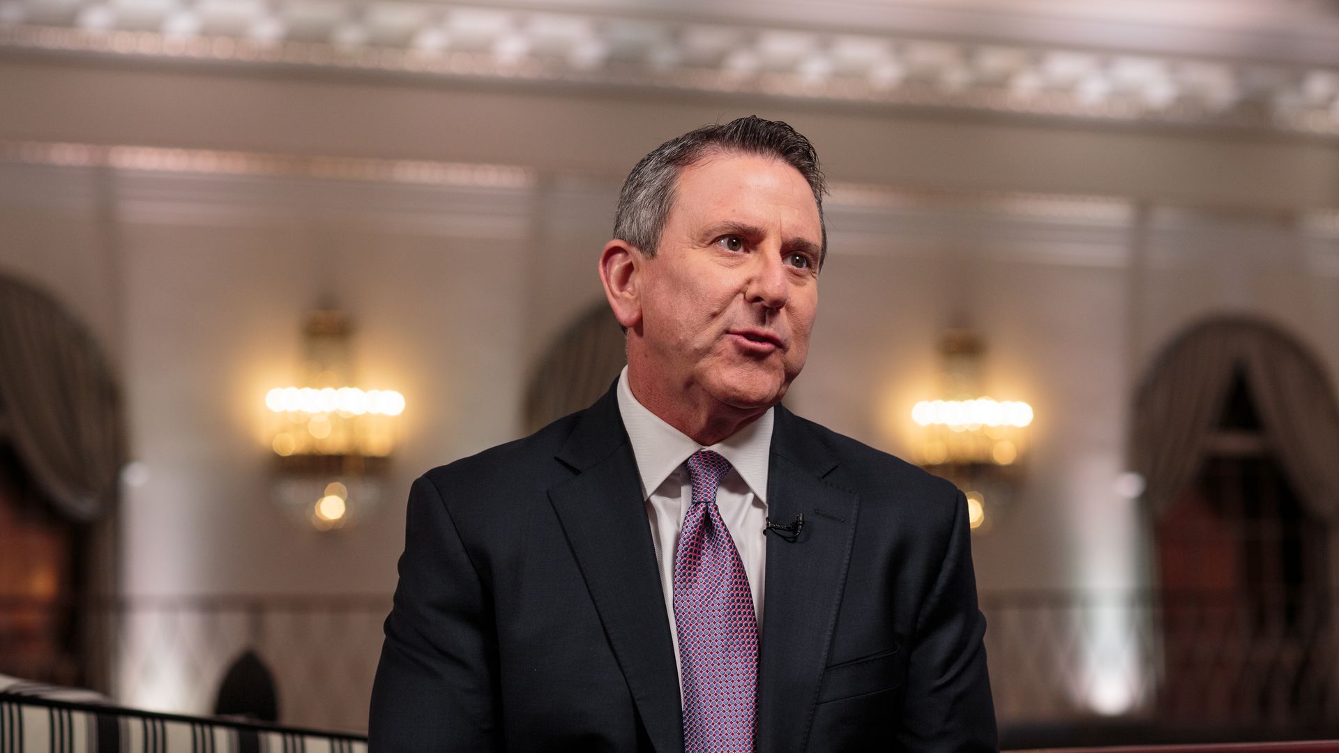 Brian Cornell sits in a suit and appears to be talking