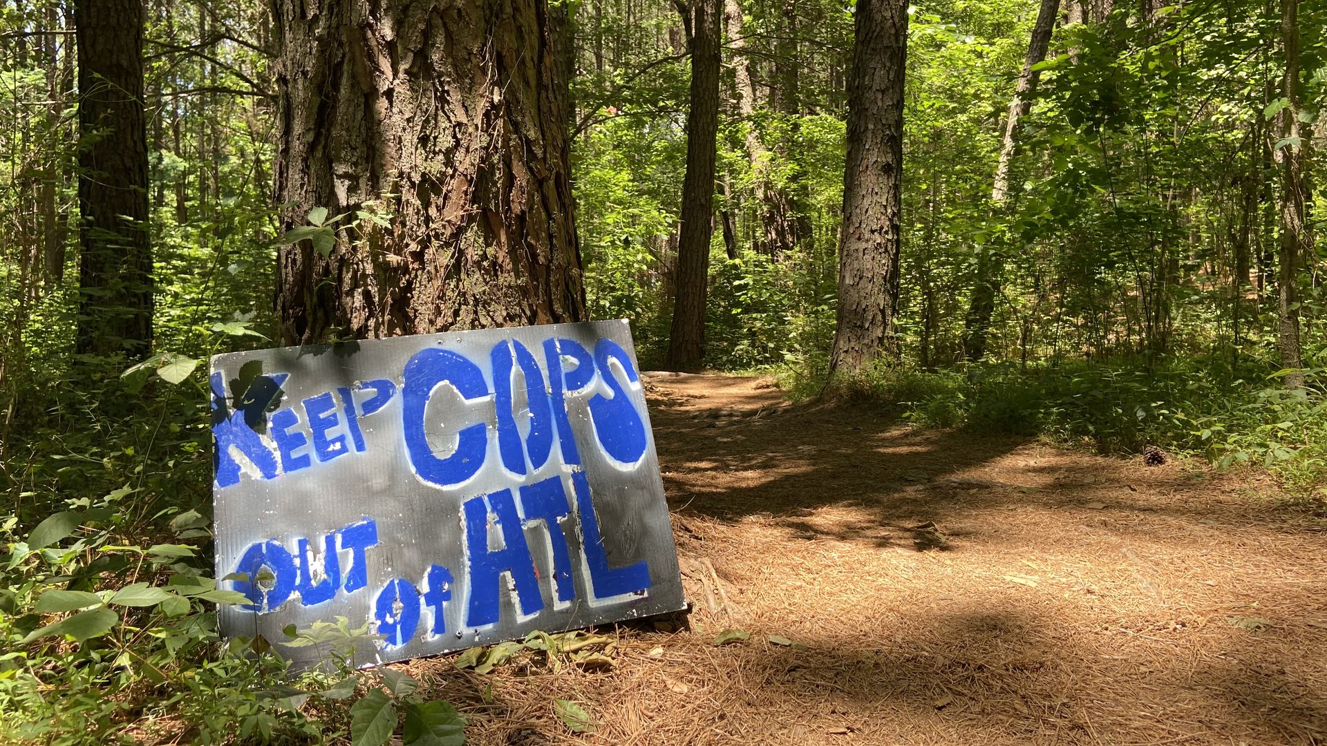 A sign saying “keep cops out of ATL” leading into a tent city created by activists opposed to the Atlanta police academy 
