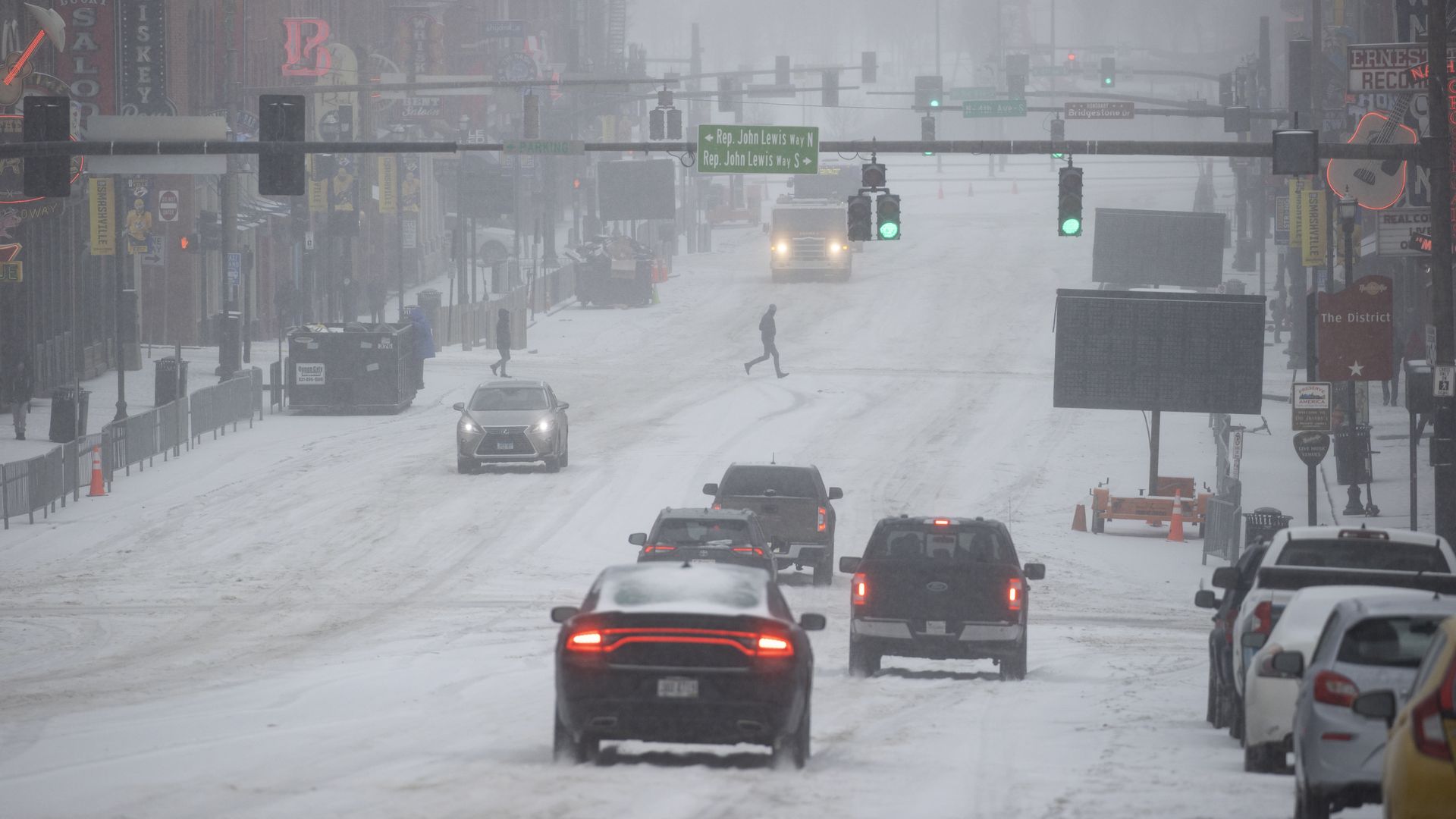 General view of Lower Broadway as vehicles and people traverse through snow and ice on February 15