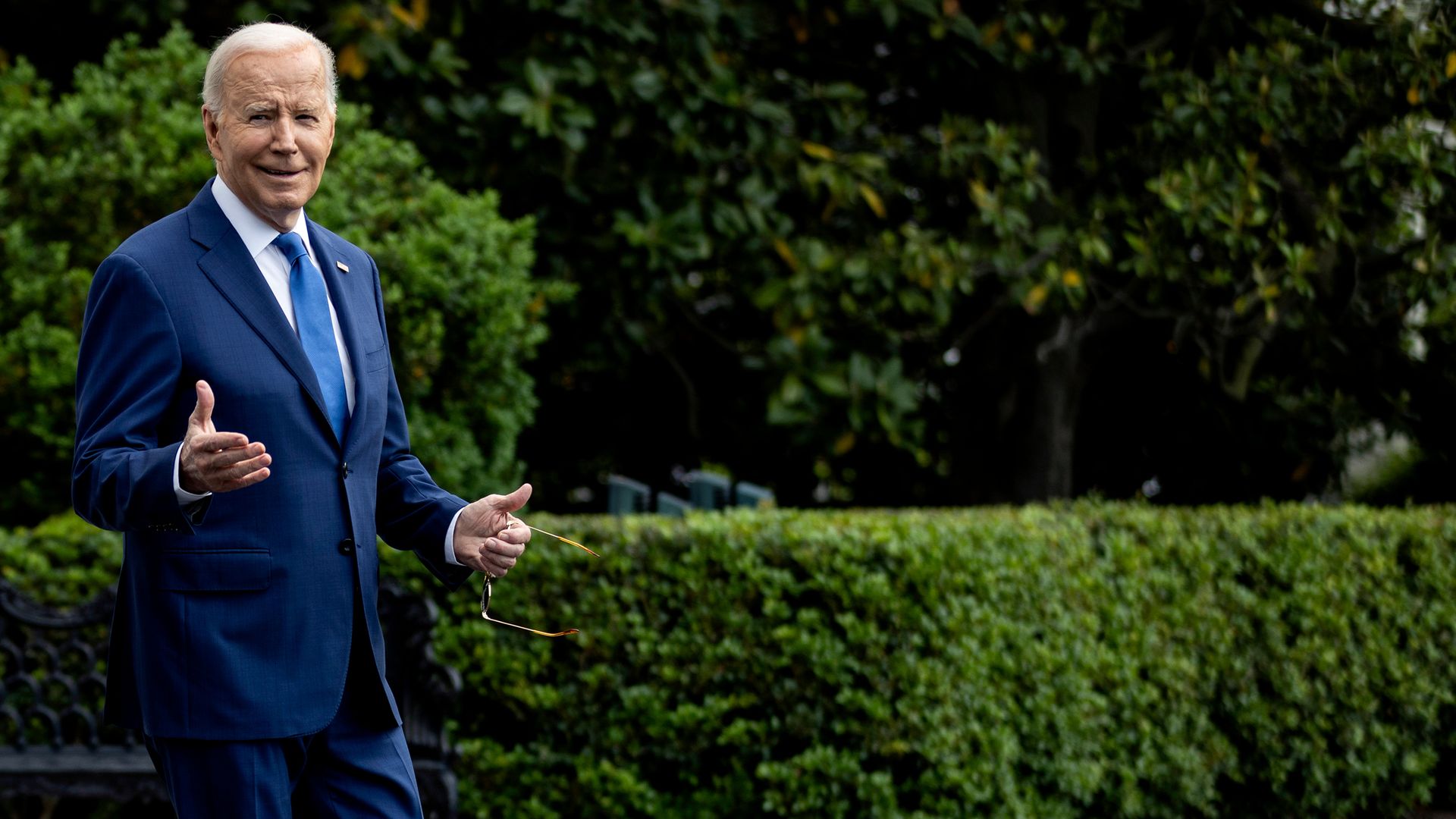 President Biden in a blue suit outside the White House.