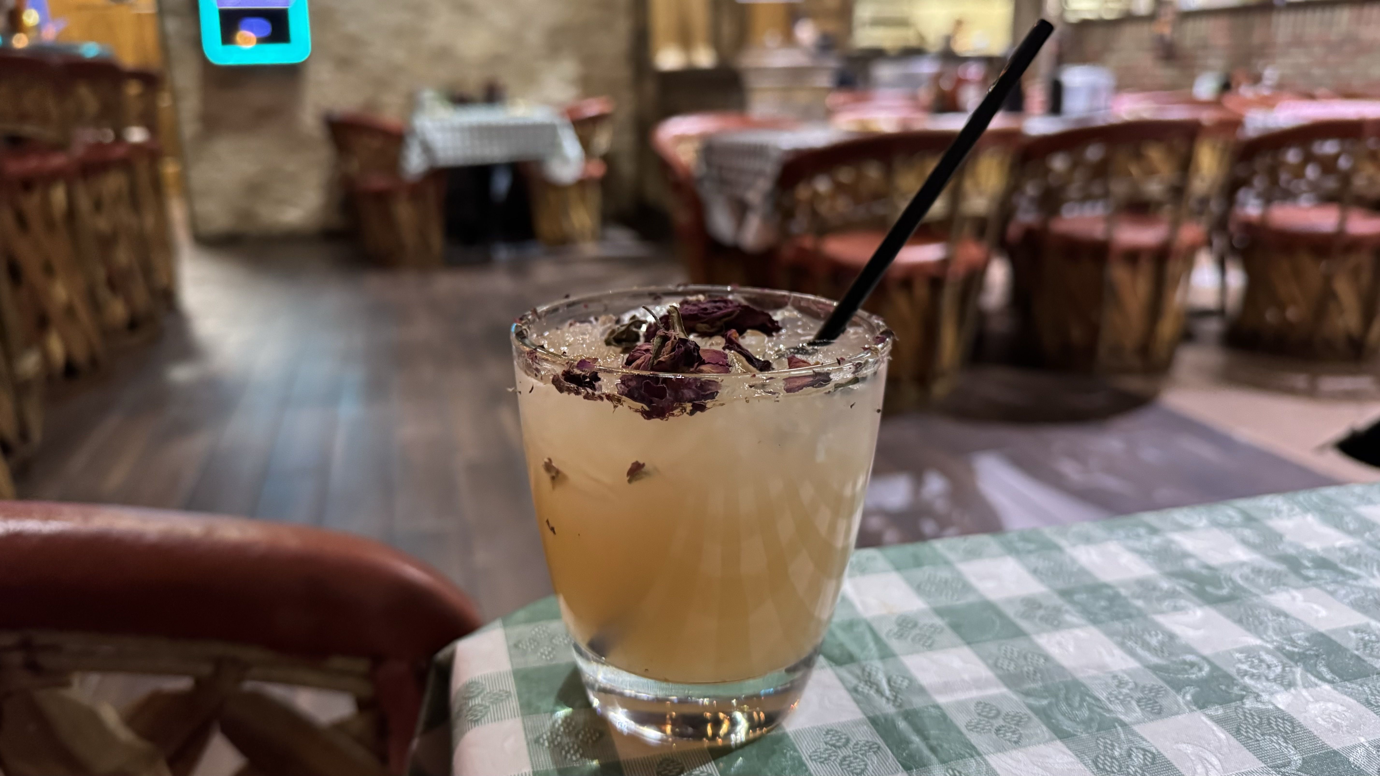 A pink-ish drink with flower petals in it.