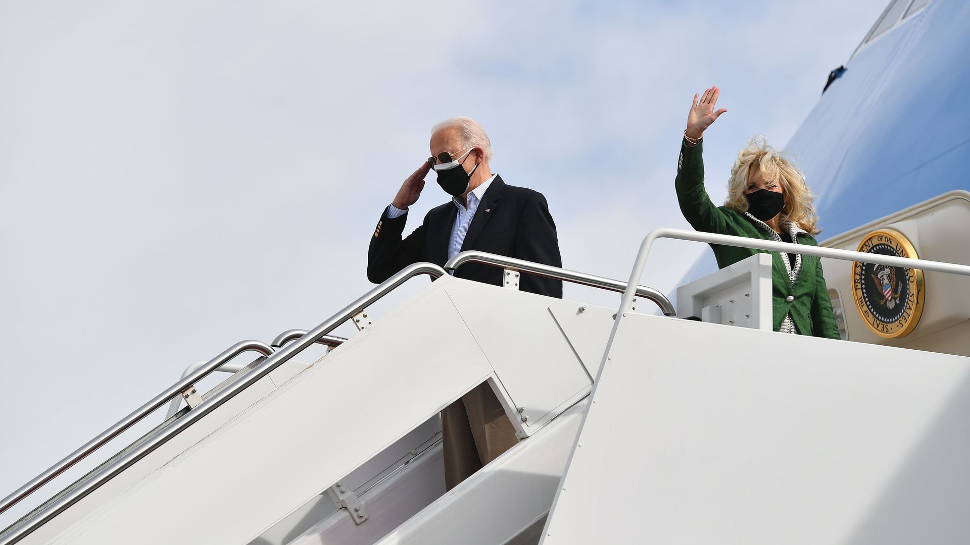 Jill Biden is seen waving while President Biden salutes before they board Air Force One.