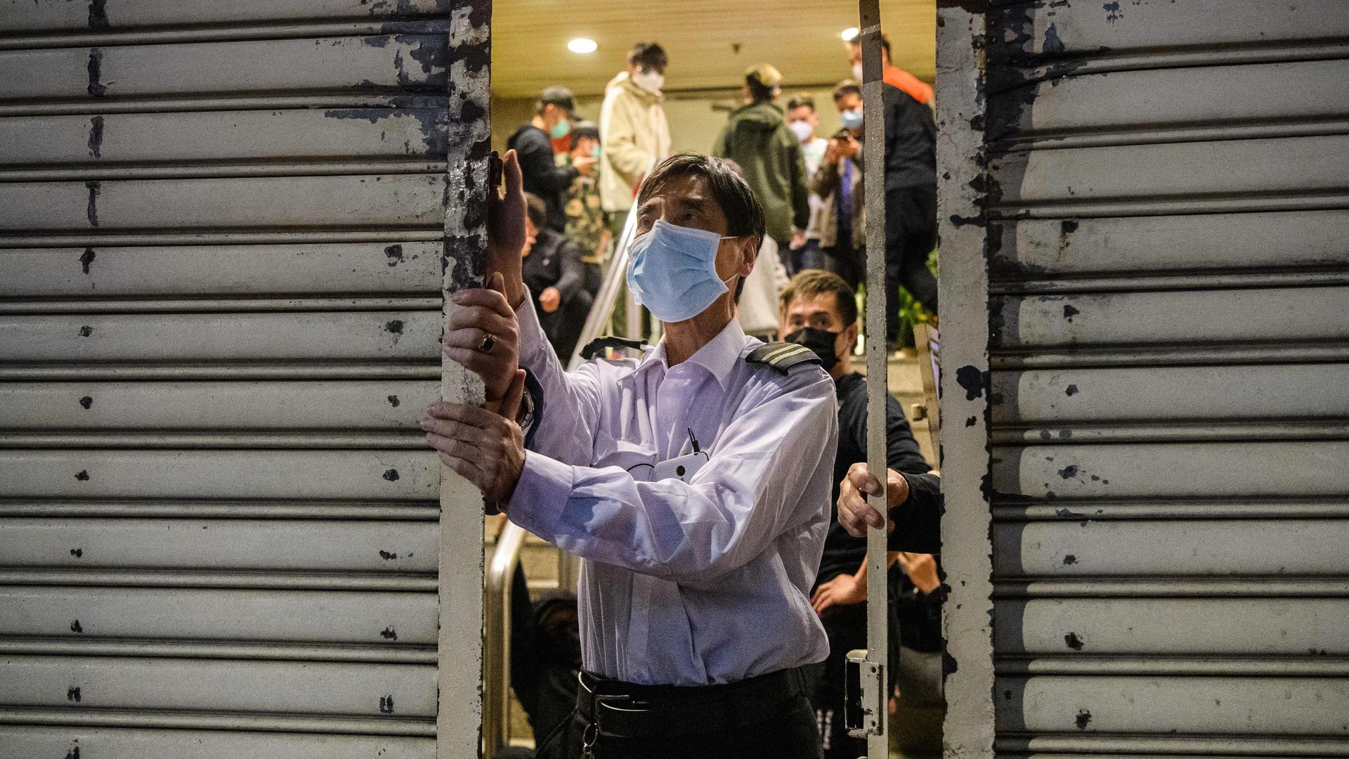 A security guard locks a building in Wuhan, China