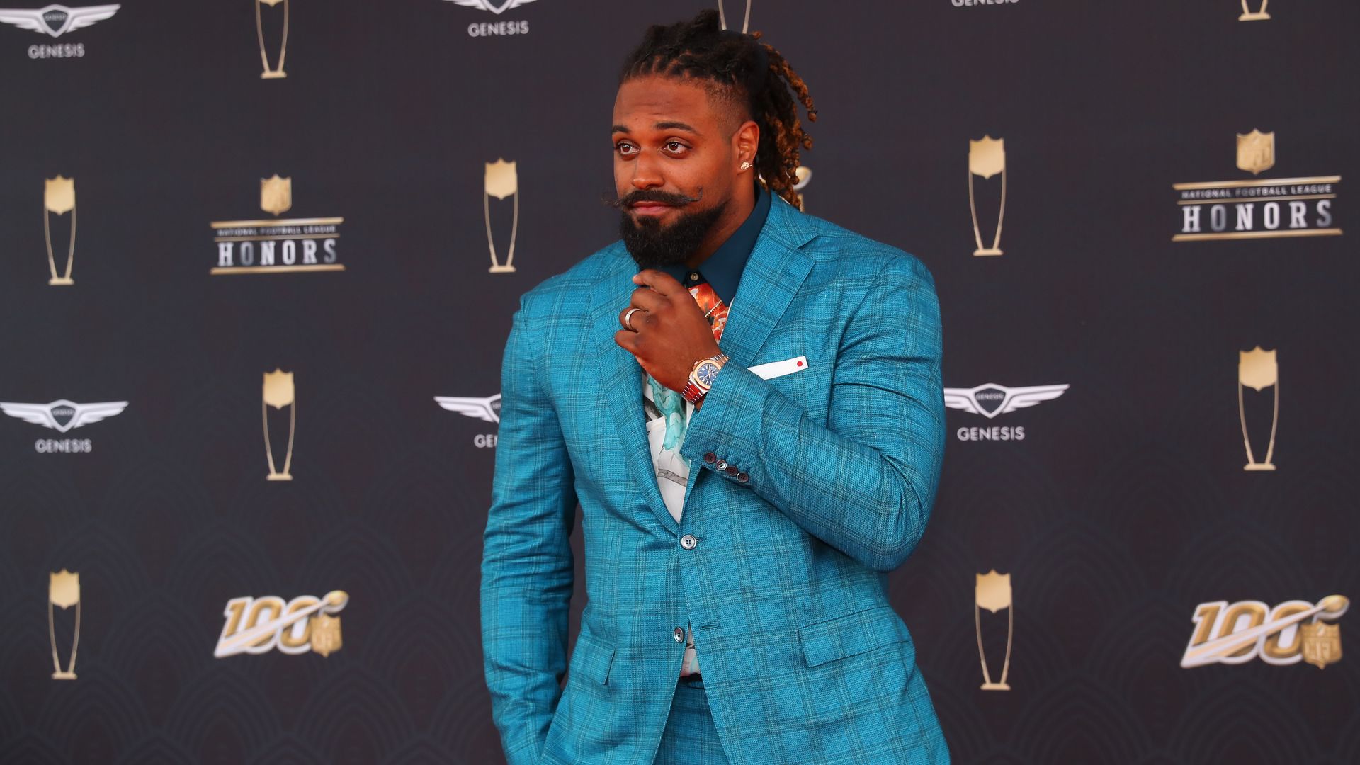 Cam Jordan wears a blue suit on a red carpet for the NFL Honors.