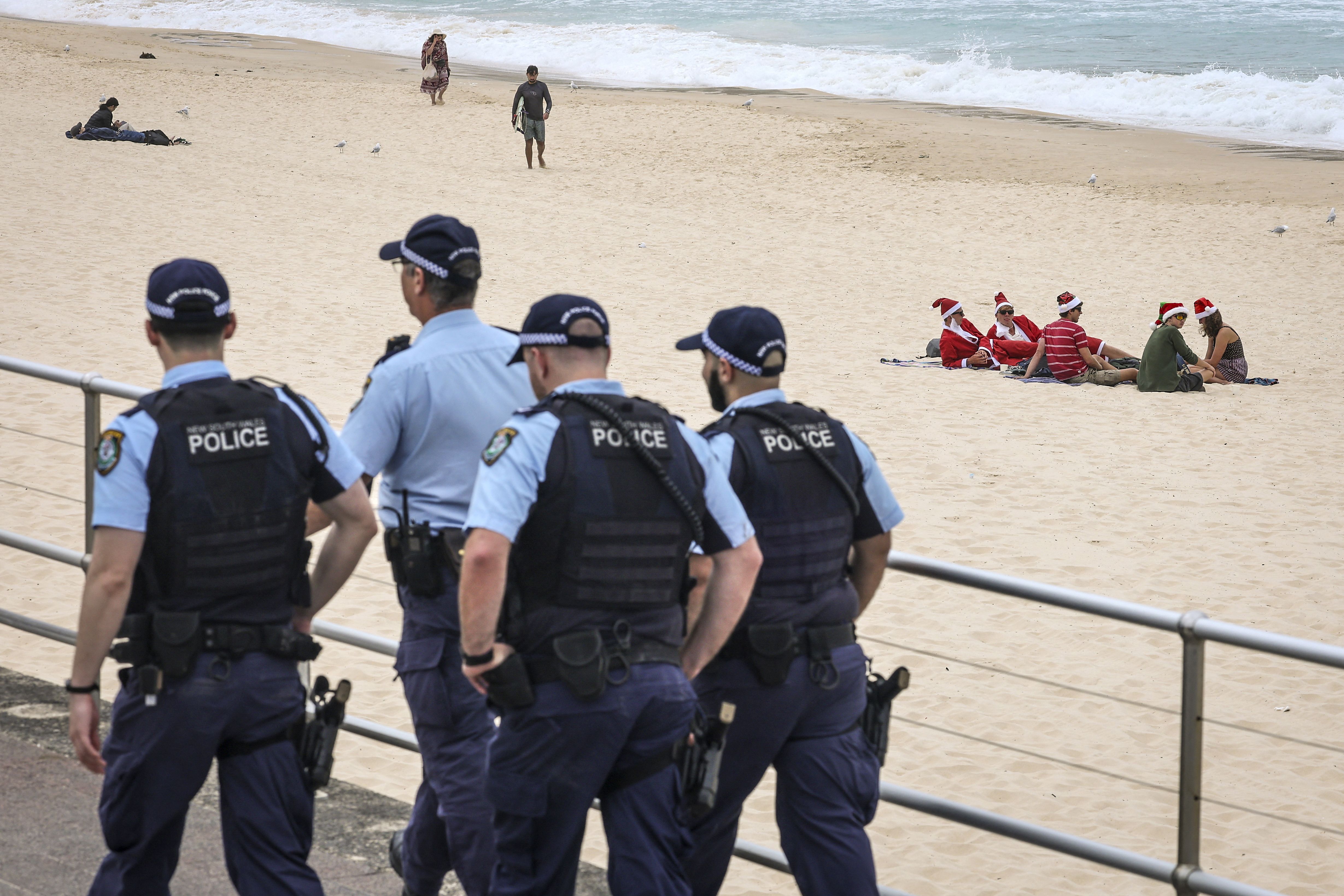 Police patrol near beachgoers at Bondi Beach in Sydney on Christmas Day, less than two weeks after a deadly shooting at a Hanukkah festival there.