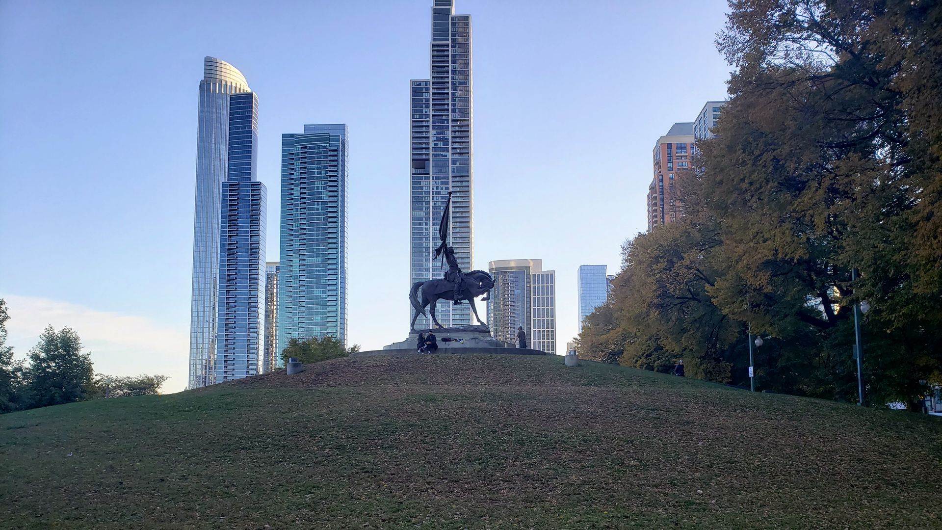Statue on a mound in front of tall buildings