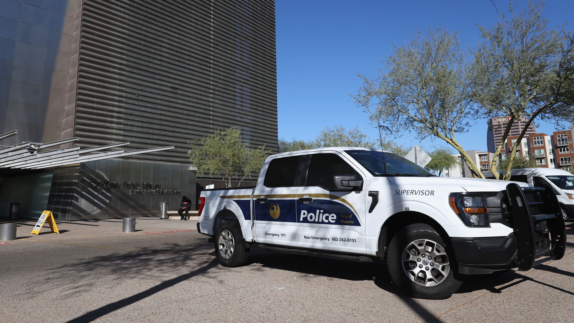 A Phoenix Police Department pickup truck is parked outside a building. 