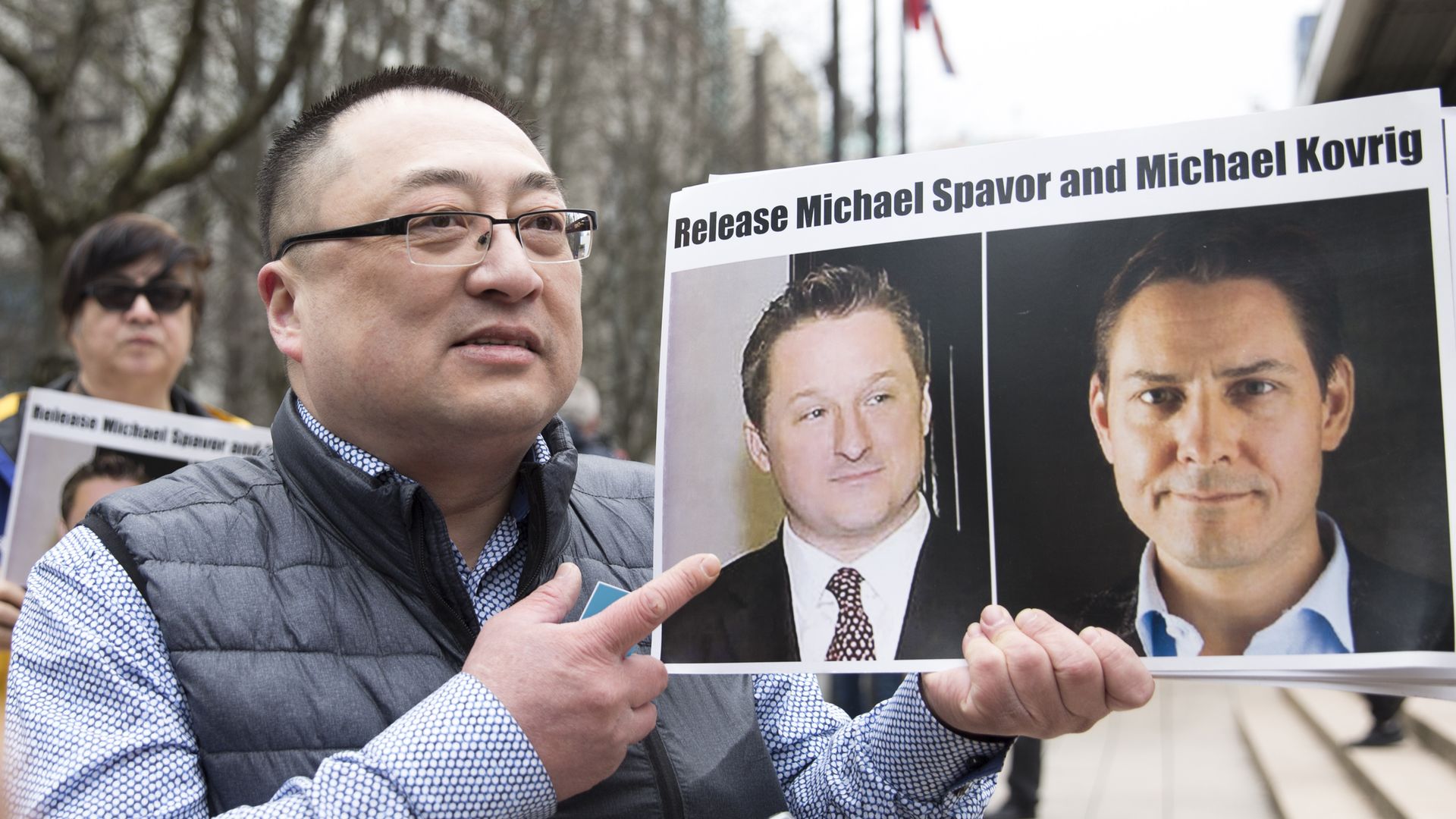A protester in 2019 holds photos of Canadians Michael Spavor and Michael Kovrig, who are being detained by China, outside British Columbia Supreme Court, in Vancouver
