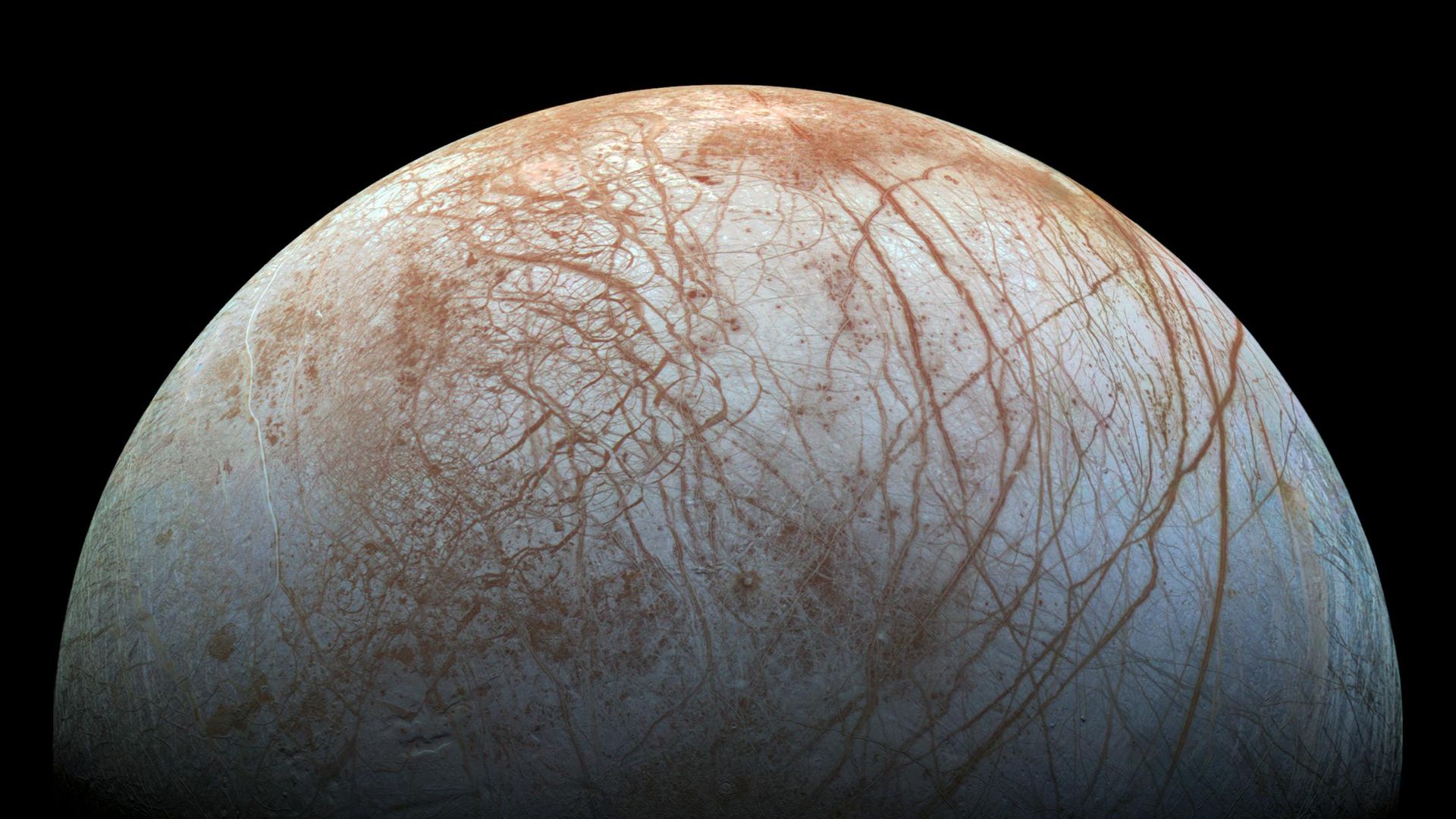 A view of Europa with its white surface and maroon lines 