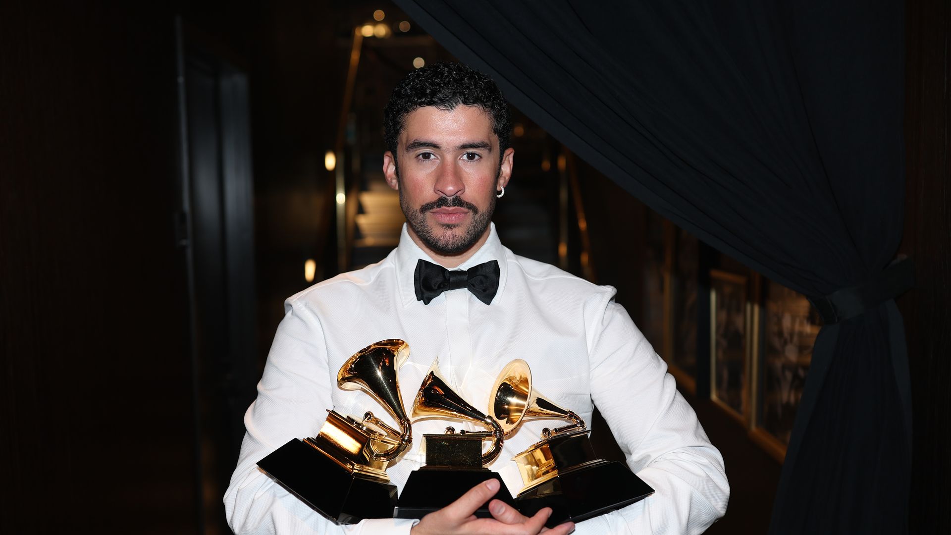 bad bunny in a suit with all his Grammys