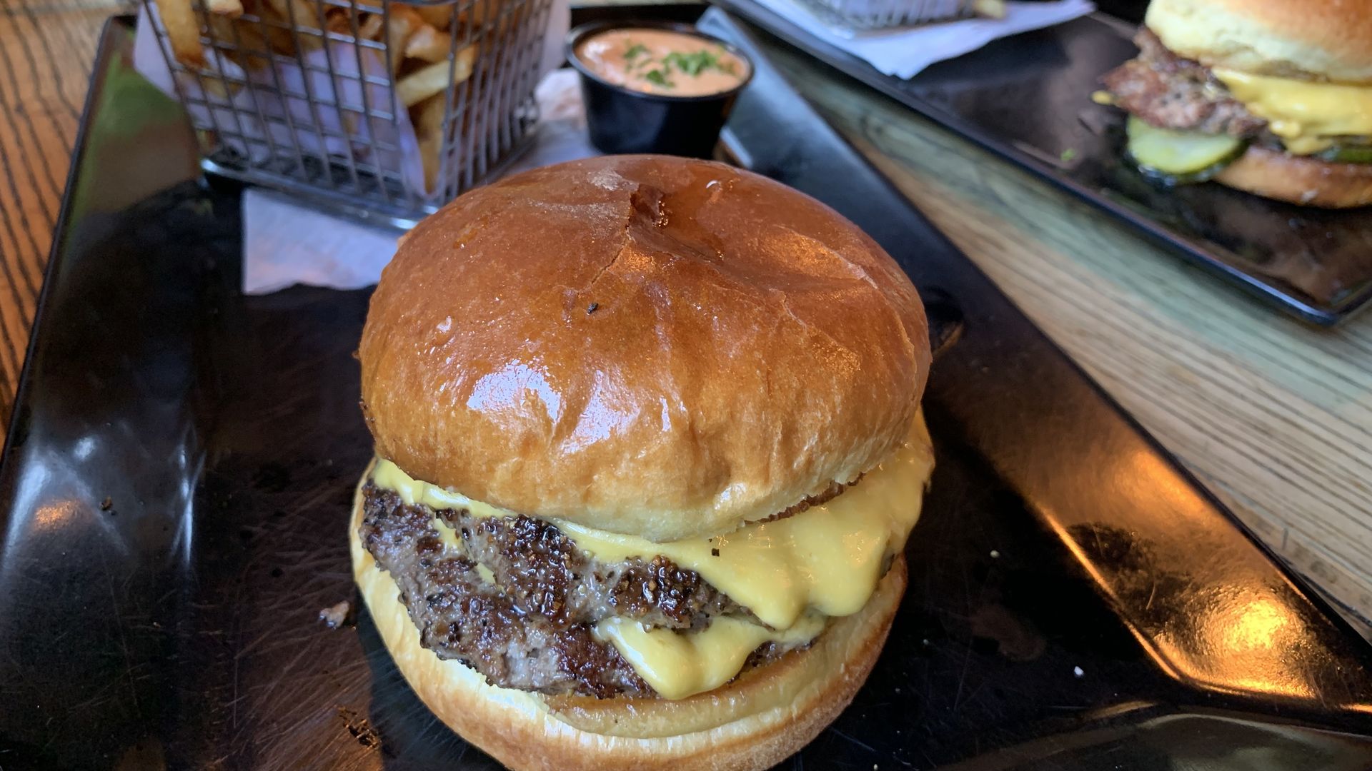 Photo of a cheeseburger on a plate with fries 