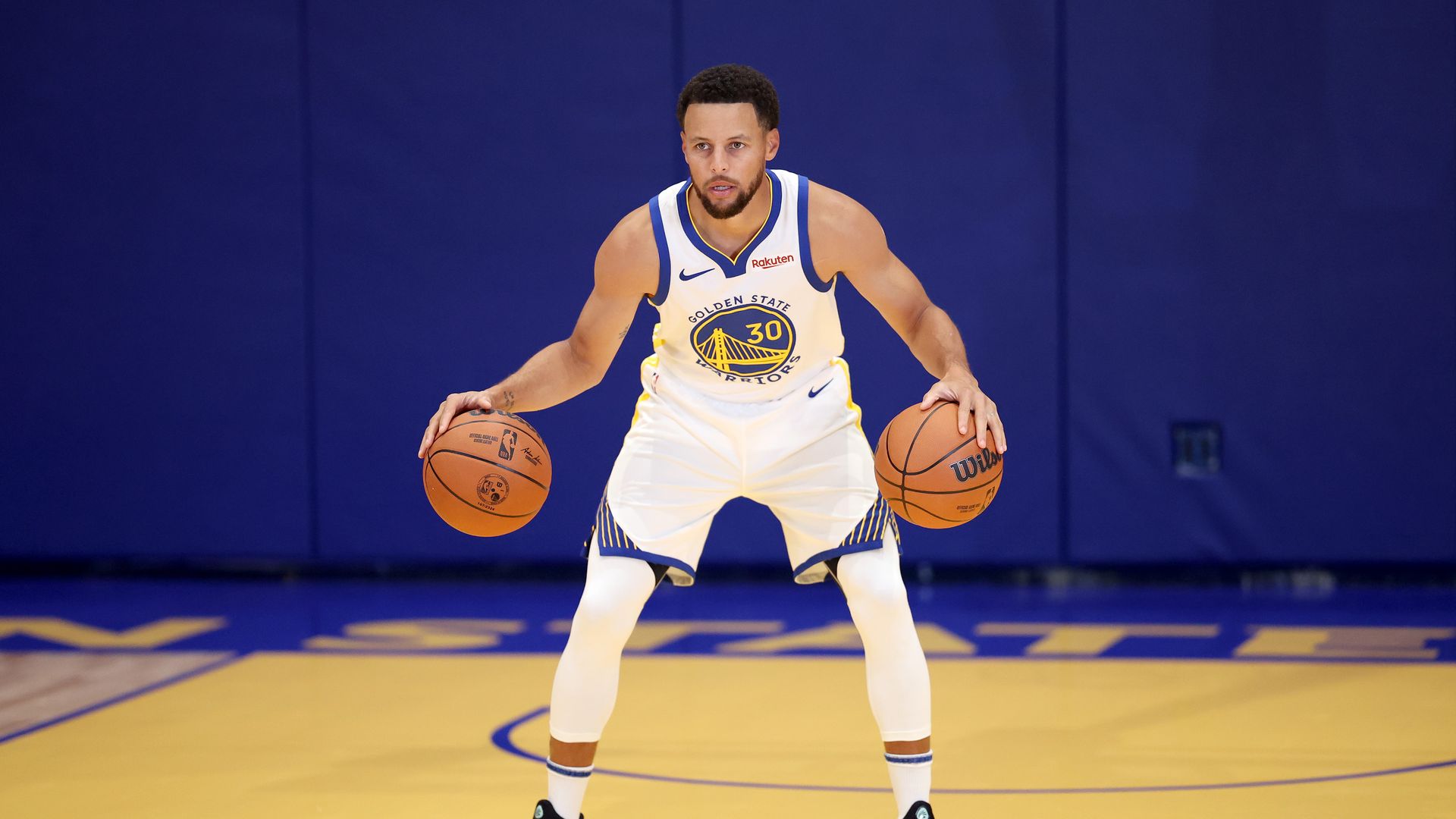 Photo of Stephen Curry dribbling two basketballs, one in each hand