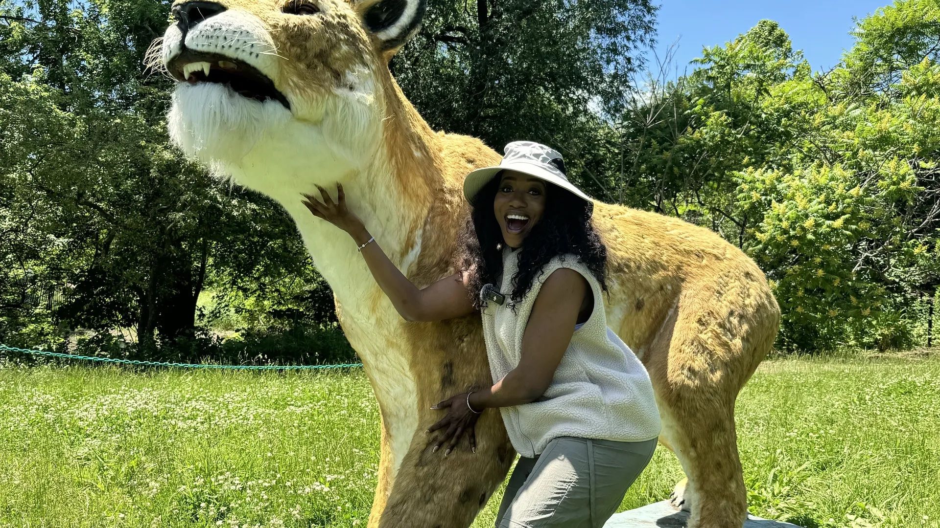 person standing next to a large animatronic animal