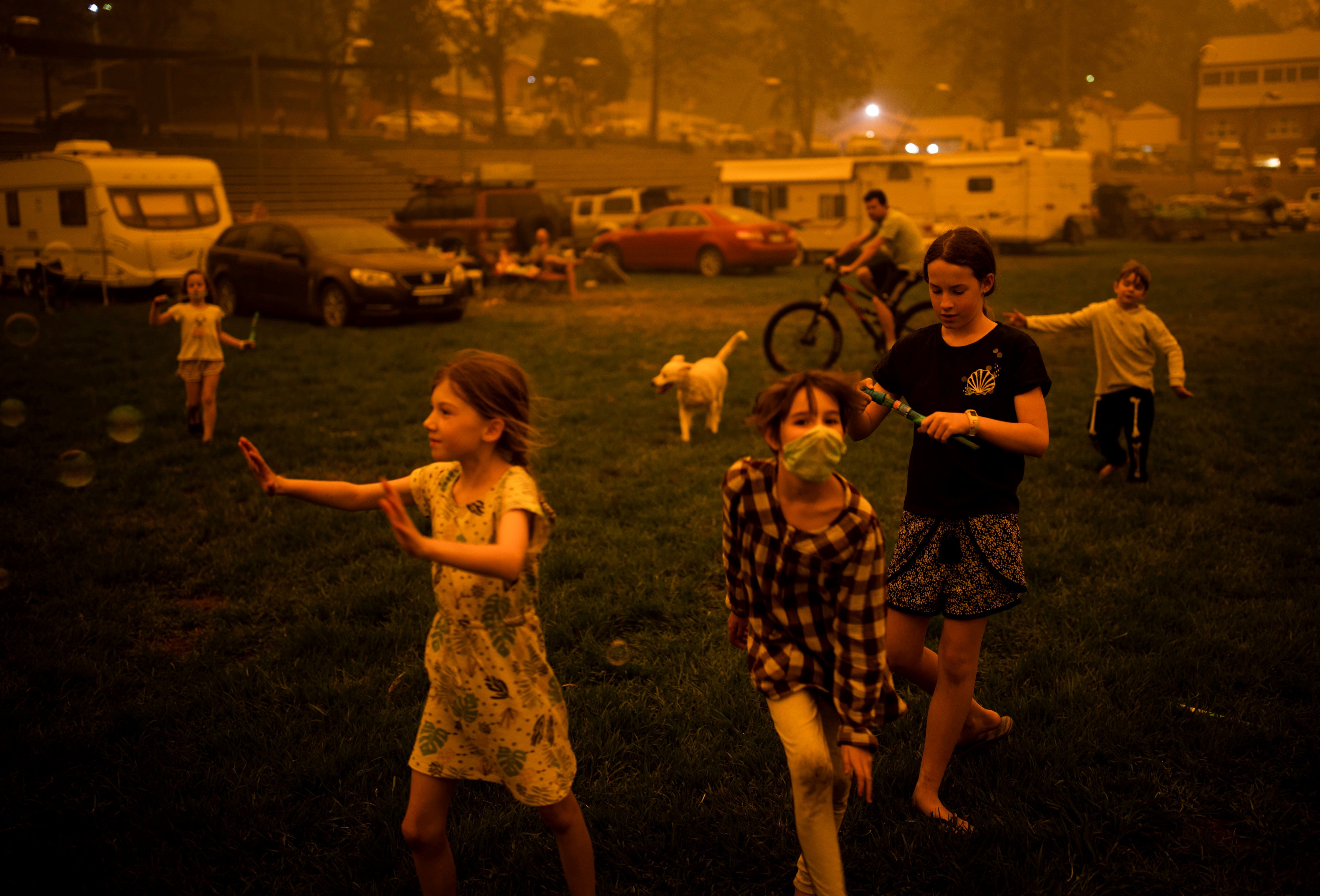 Children play at the showgrounds in the southern New South Wales town of Bega where they are camping after being evacuated from nearby sites affected by bushfires on December 31