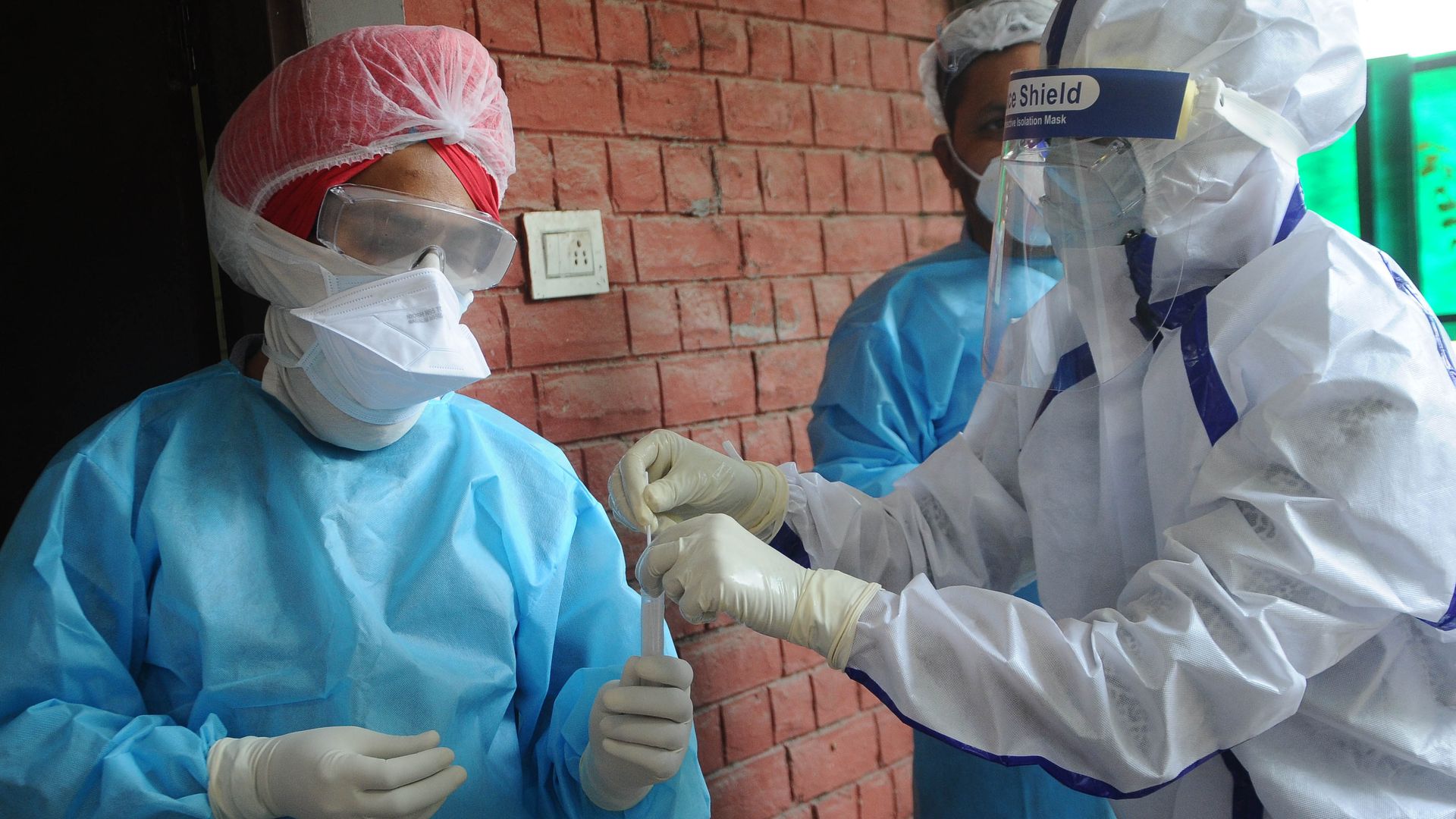 Health care workers handling a sample being tested for coronavirus.