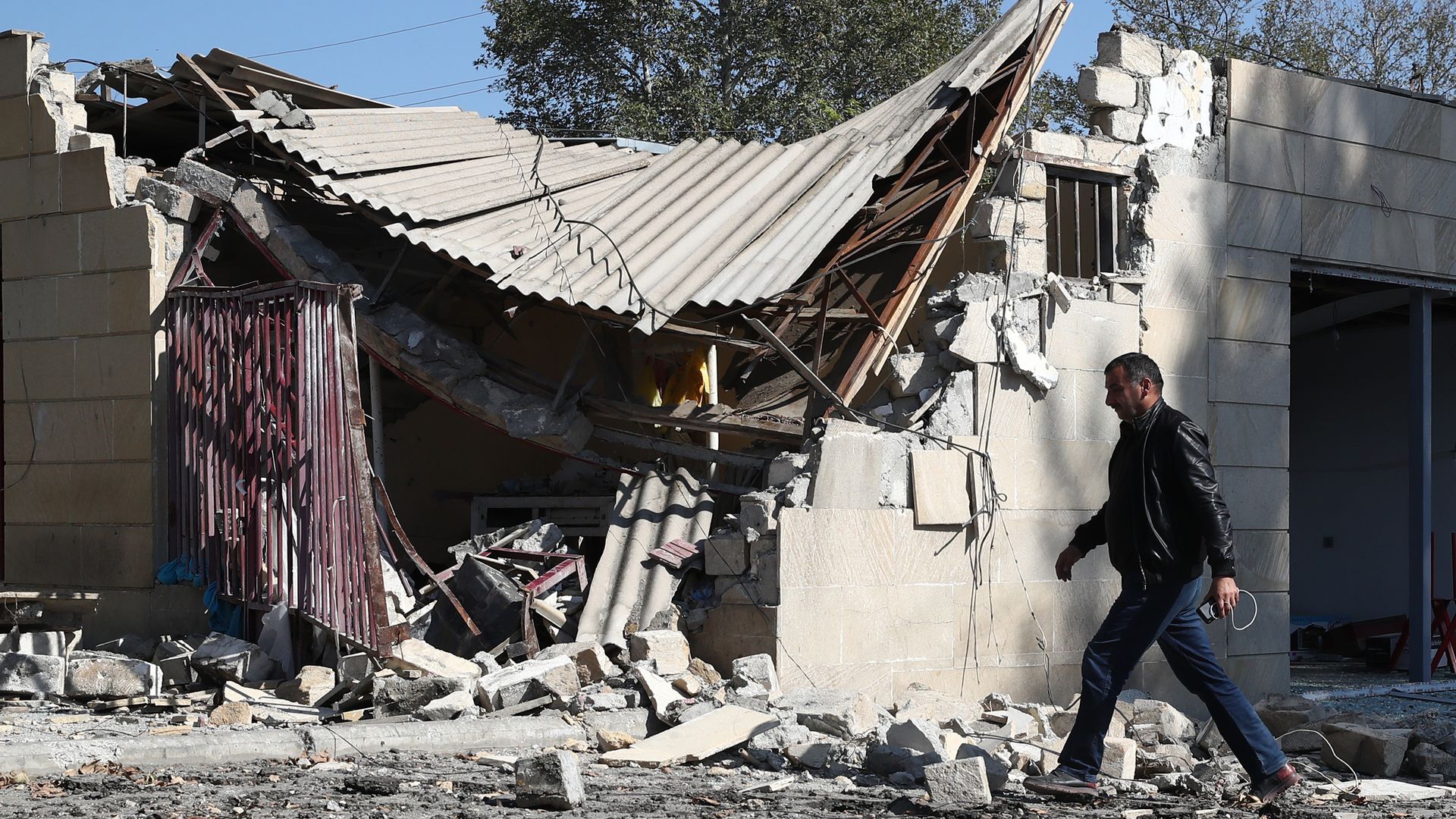 A man walks past a market damaged in a shelling attack in Nagorno-Karabakh. Photo: Valery Sharifulin\TASS via Getty Images