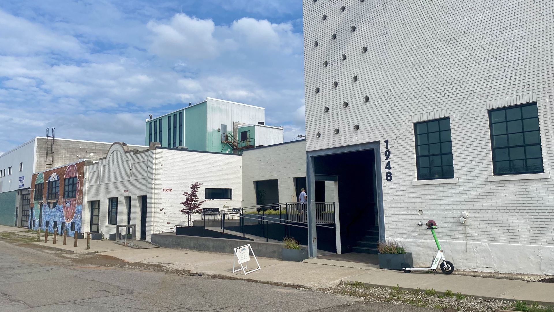 A white building with several business bays in Eastern Market.