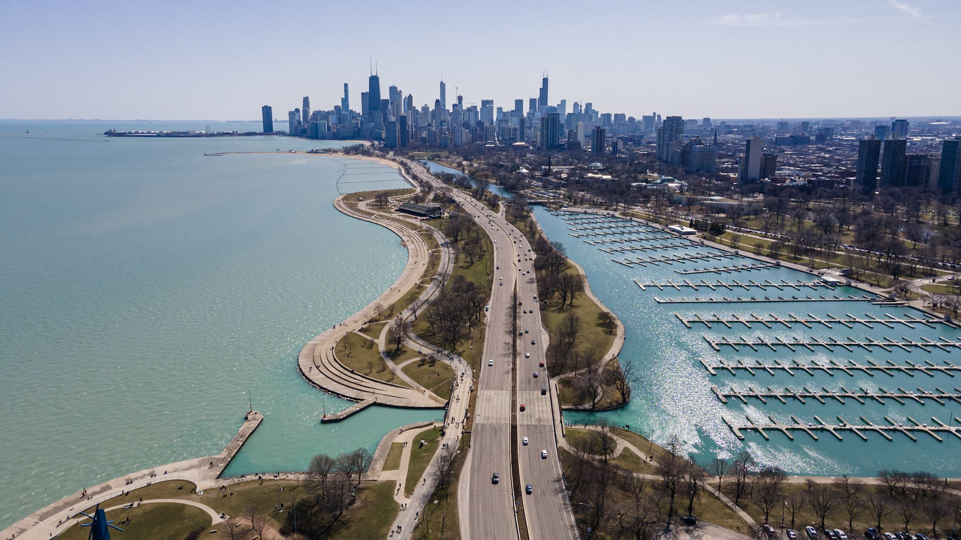 A photo of a highway with the lake surrounding both sides.