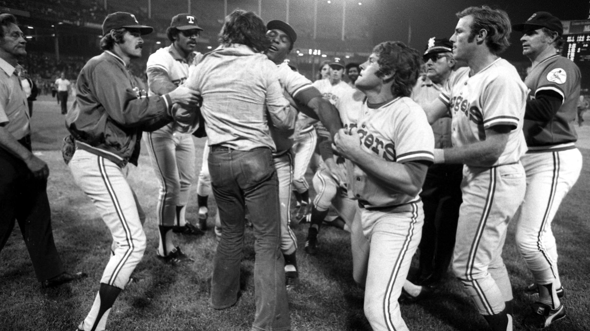 A photo from June 4, 1974, showing several Texas Rangers players pushing back a fan who had run onto the baseball field 