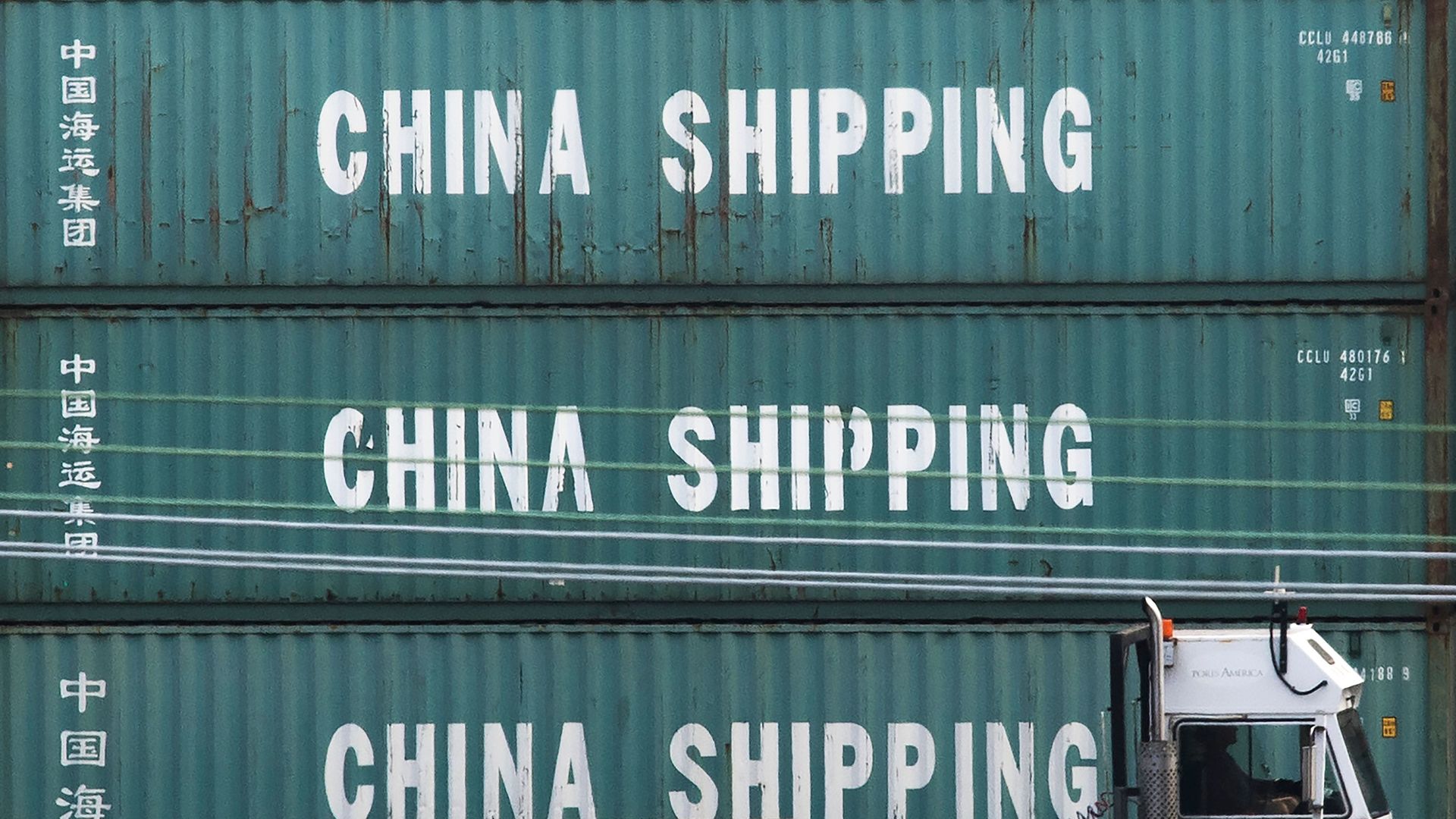 A truck passes by China Shipping containers at the Port of Los Angeles.