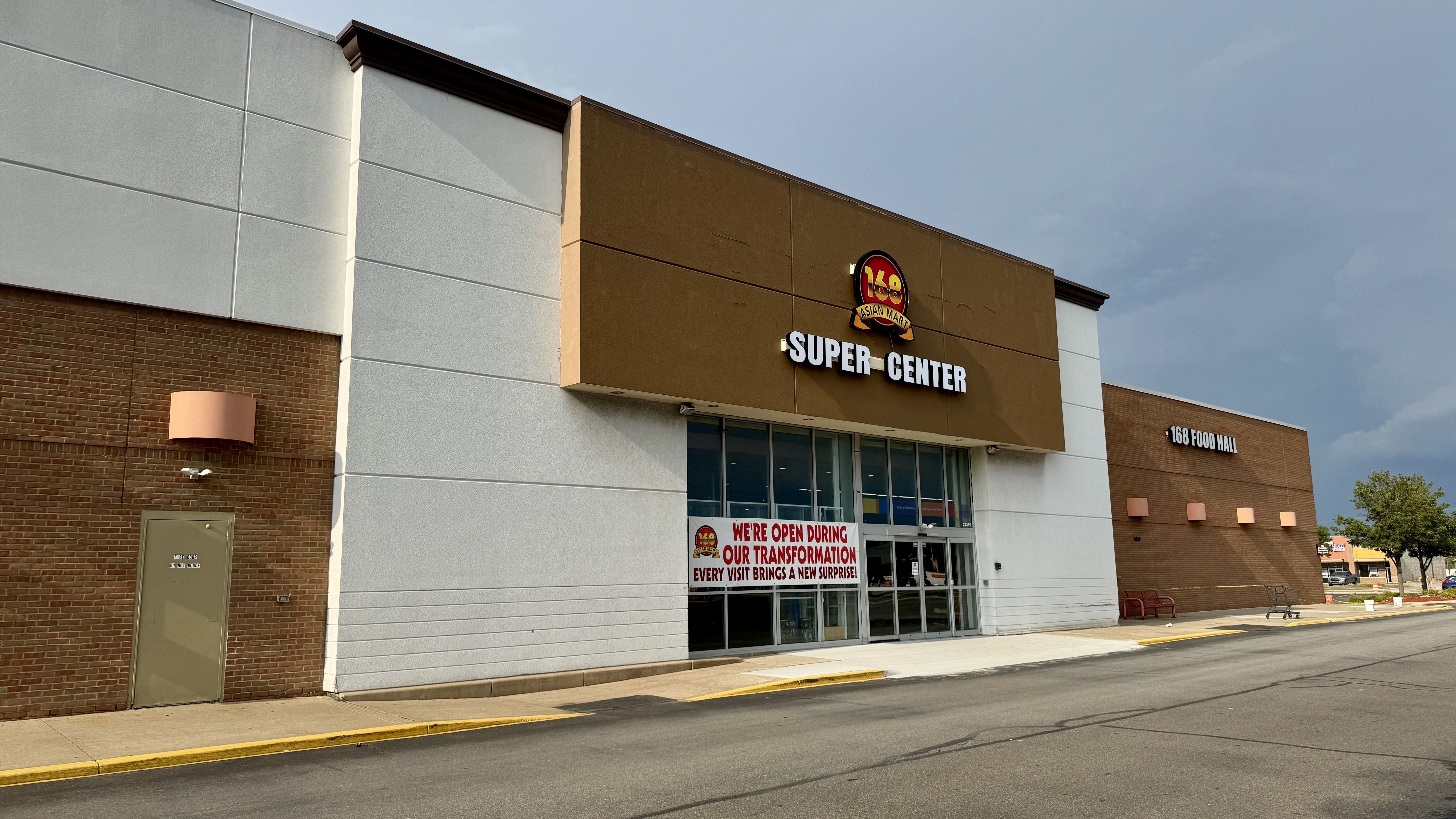 The exterior of the market, with a sign saying it's open during its transformation.