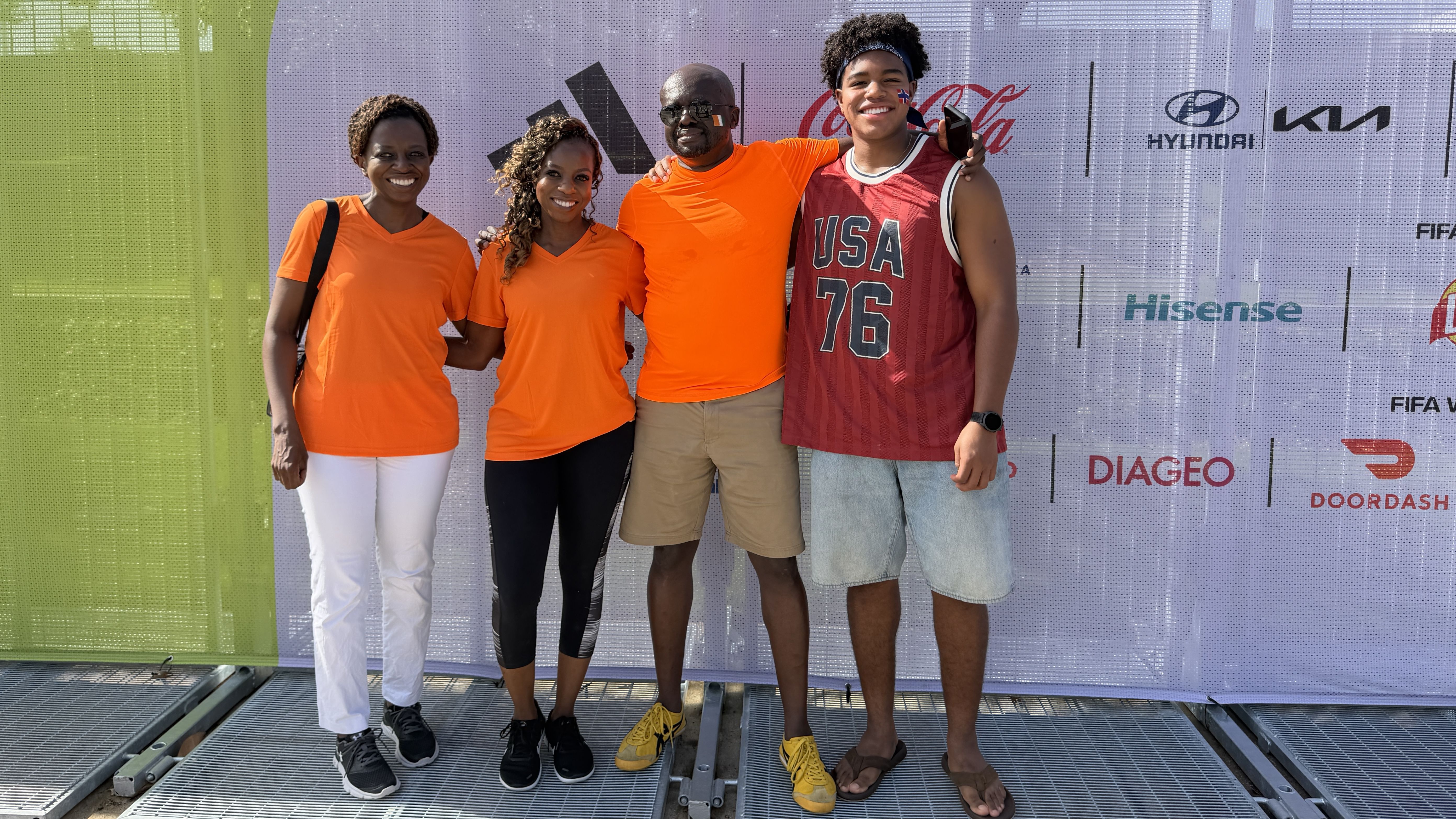 A family poses in orange shirts