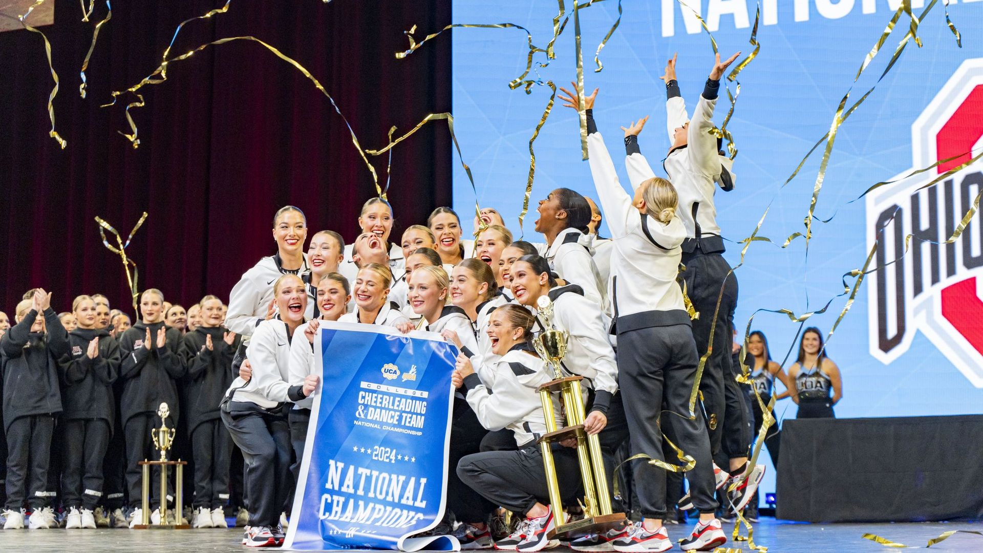 Ohio State's dance team stands with a "national champions" banner as gold ribbons fall