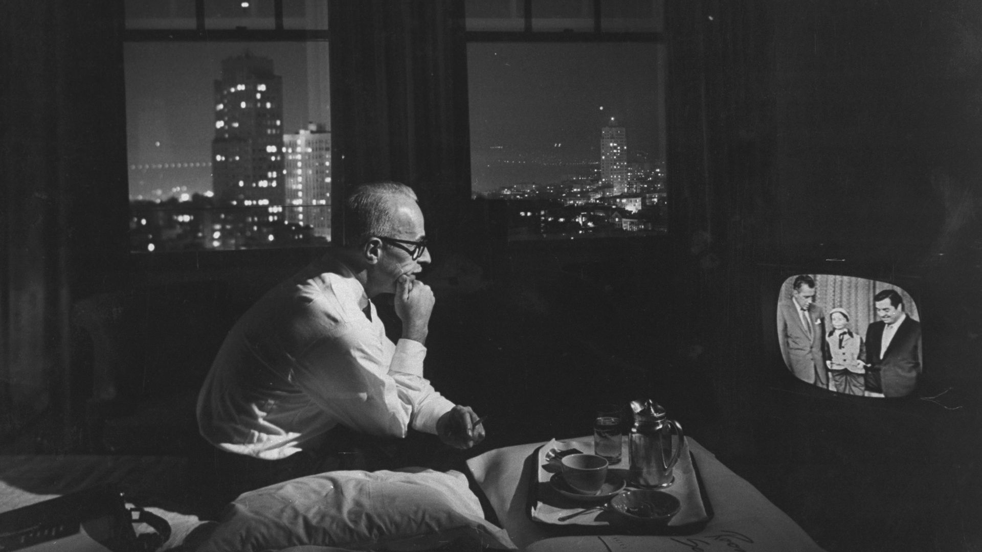 A man watching TV in a hotel room