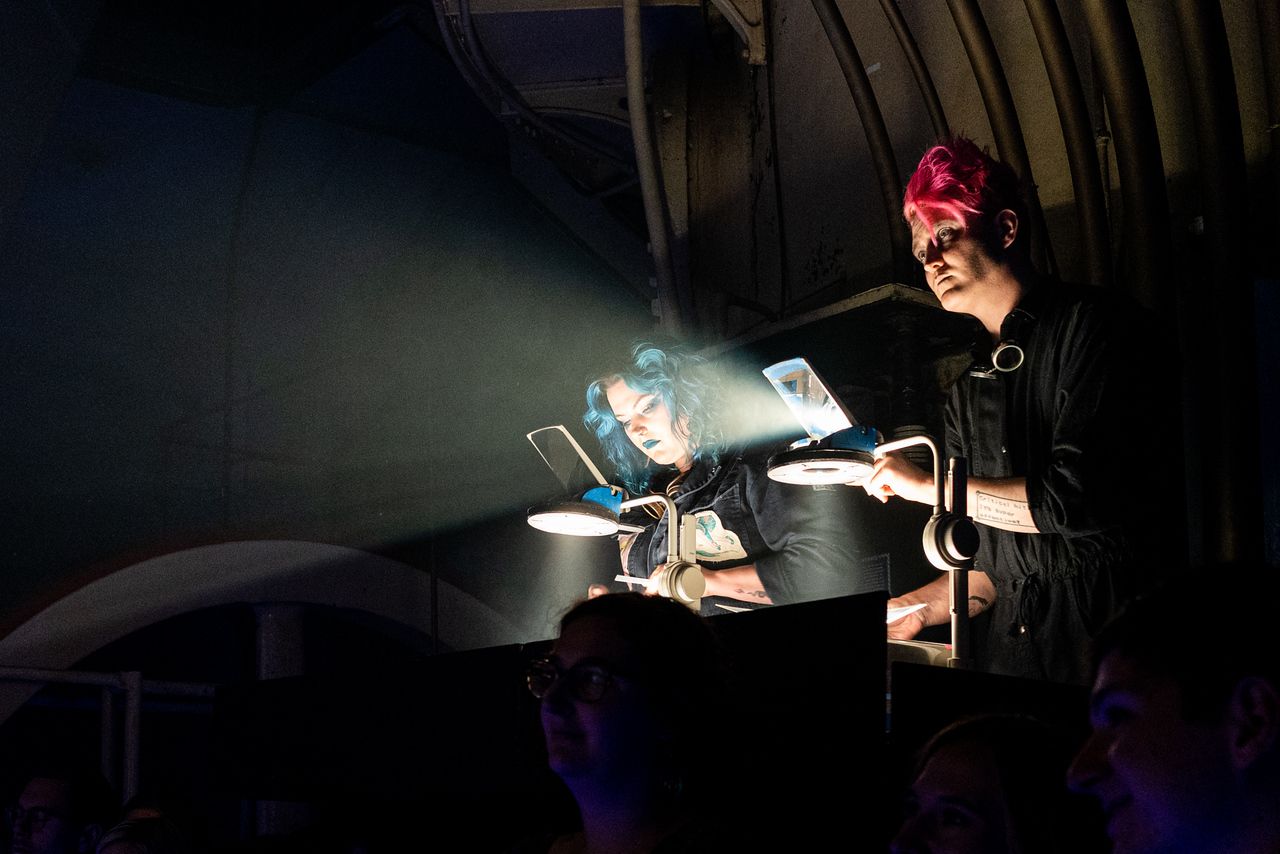Artists Cass Bray, left, and Zane Exactly operate overhead projectors during a Shadow Girls Cult performance.