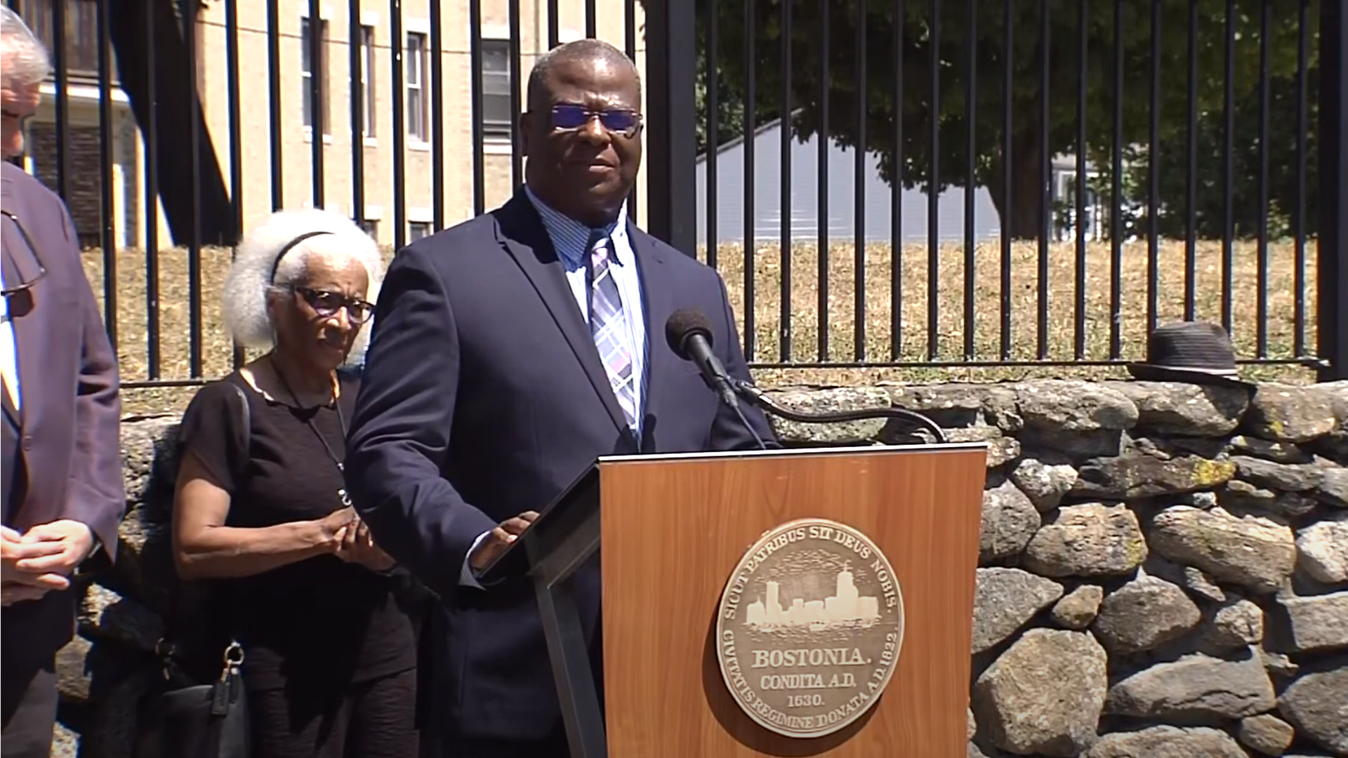 New Boston Police Commission Michael Cox speaks at a lectern.