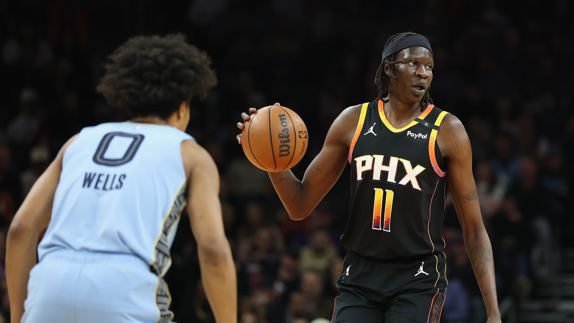 Bol Bol dribbles a basketball with a Memphis Grizzlies player defending him.