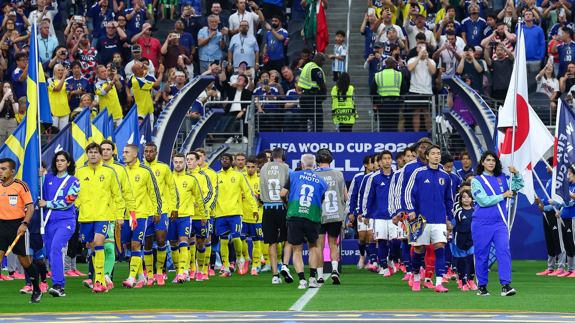 The Japan and Sweden national soccer teams walk out on the field in lines
