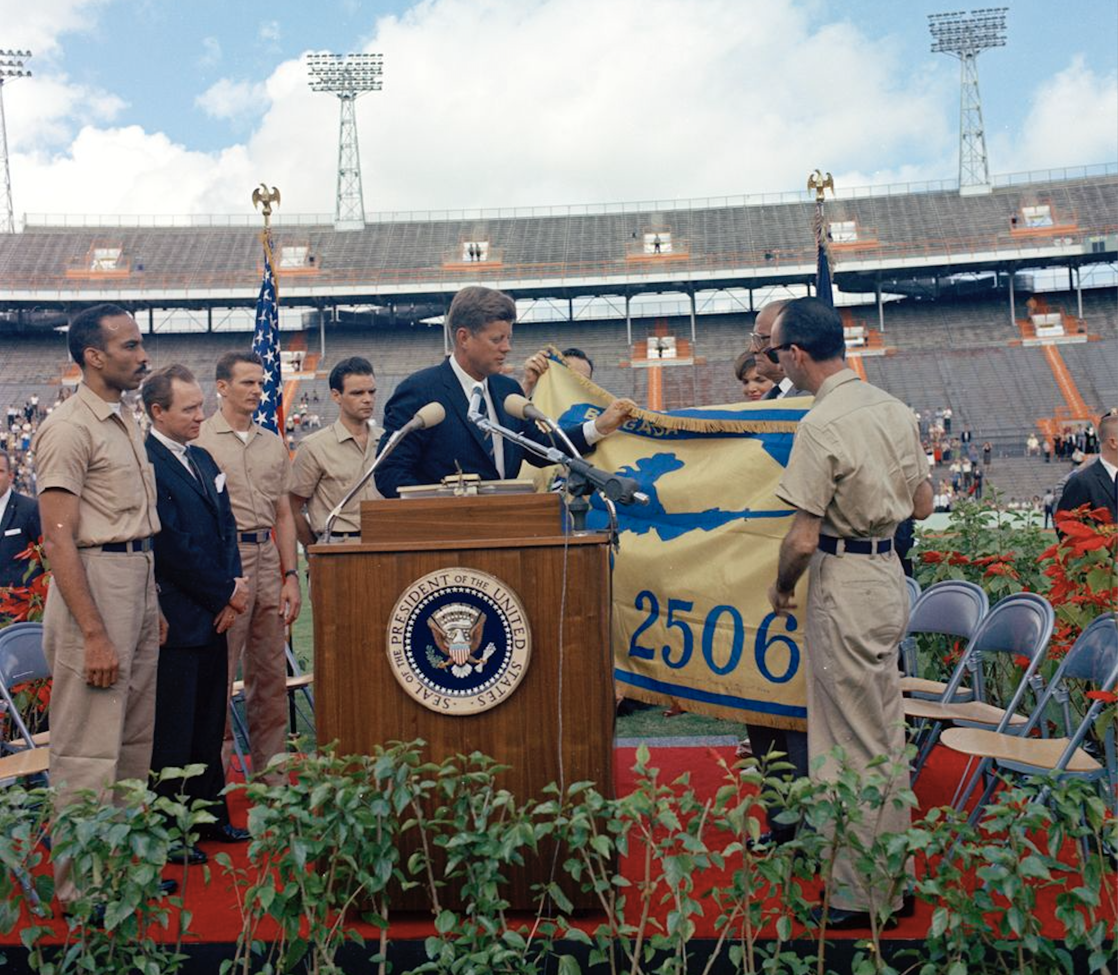 President John F. Kennedy receives the flag of the 2506th Cuban Invasion Brigade from brigade members during a presentation ceremony at the Orange Bowl Stadium in Miami, Florida.