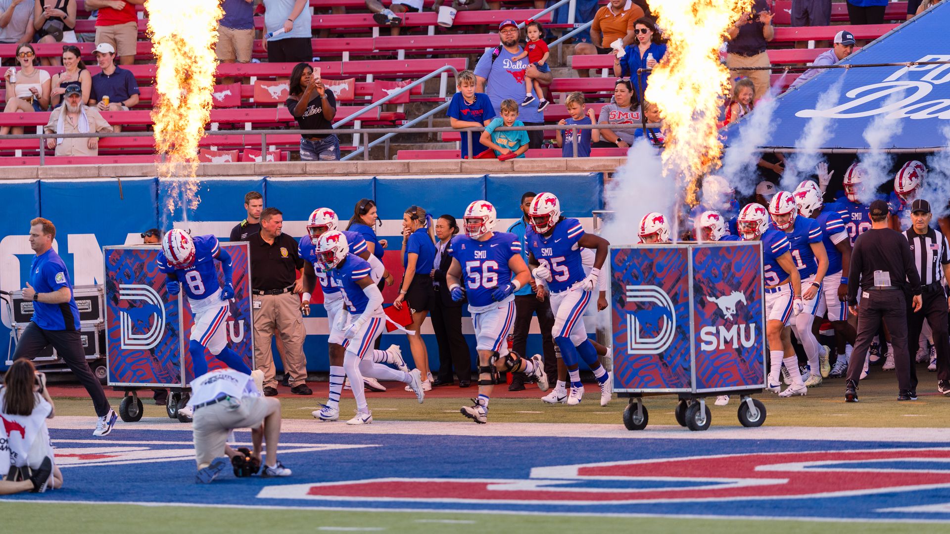 A football team in white, blue and red walks on to the field