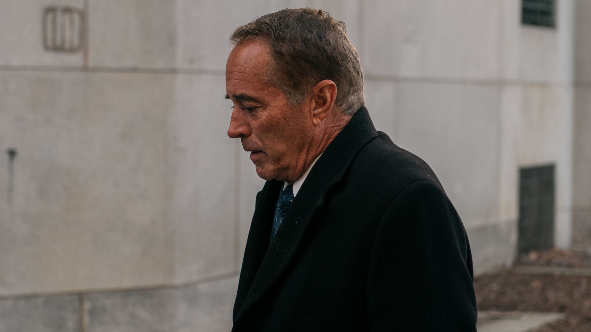 In this image, Collins walks with a coat on.