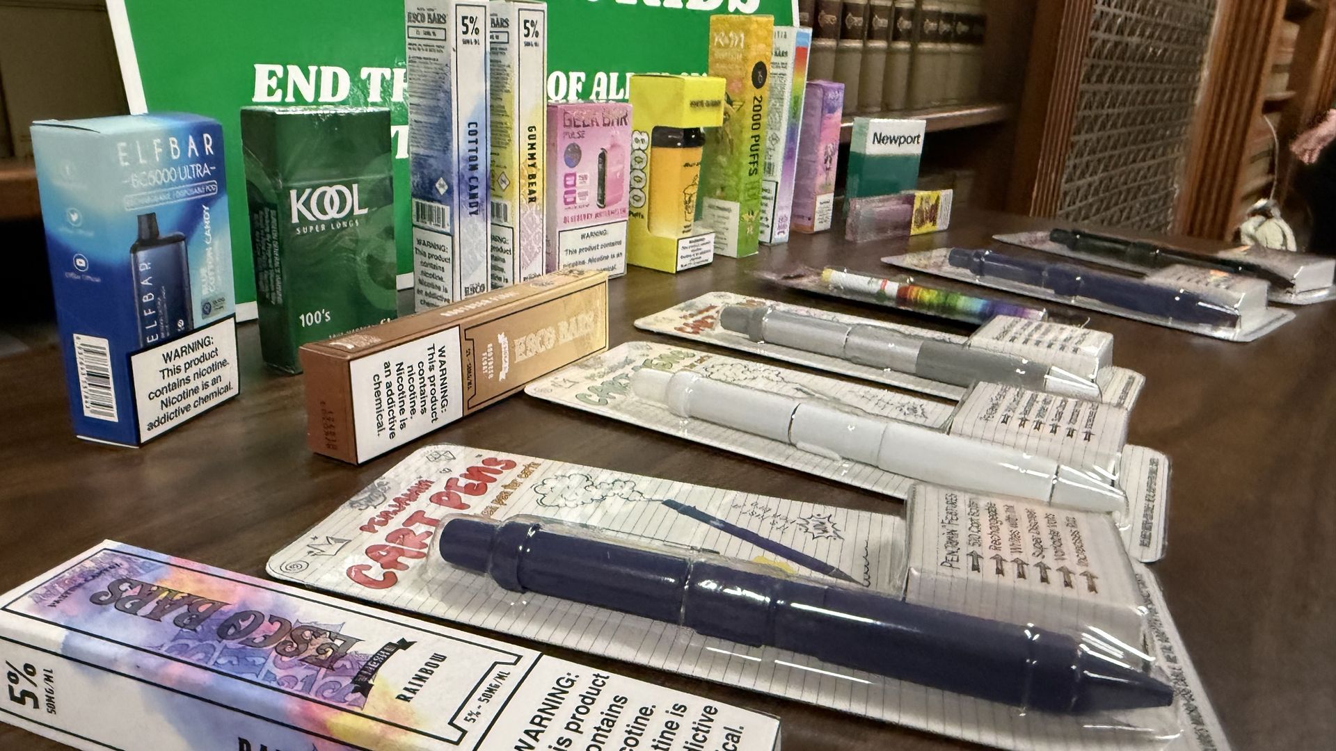 Multiple colorful packages containing tobacco products, including vapes and menthol cigarettes.