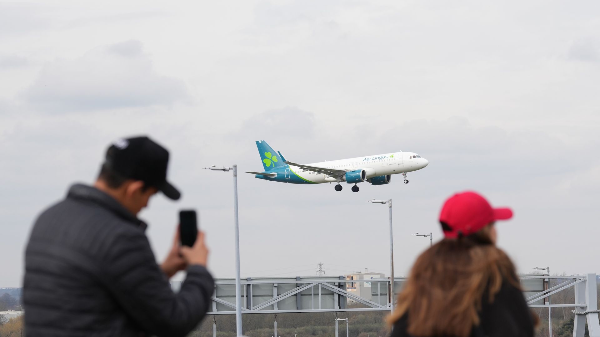 People watch an Aer Lingus plane at Heathrow Airport in London. Flights resumed at the west London airport on Friday evening and restrictions on overnight flights were temporarily lifted following hours of closure, after a blaze knocked out an electricity substation in Hayes late on Thursday evening