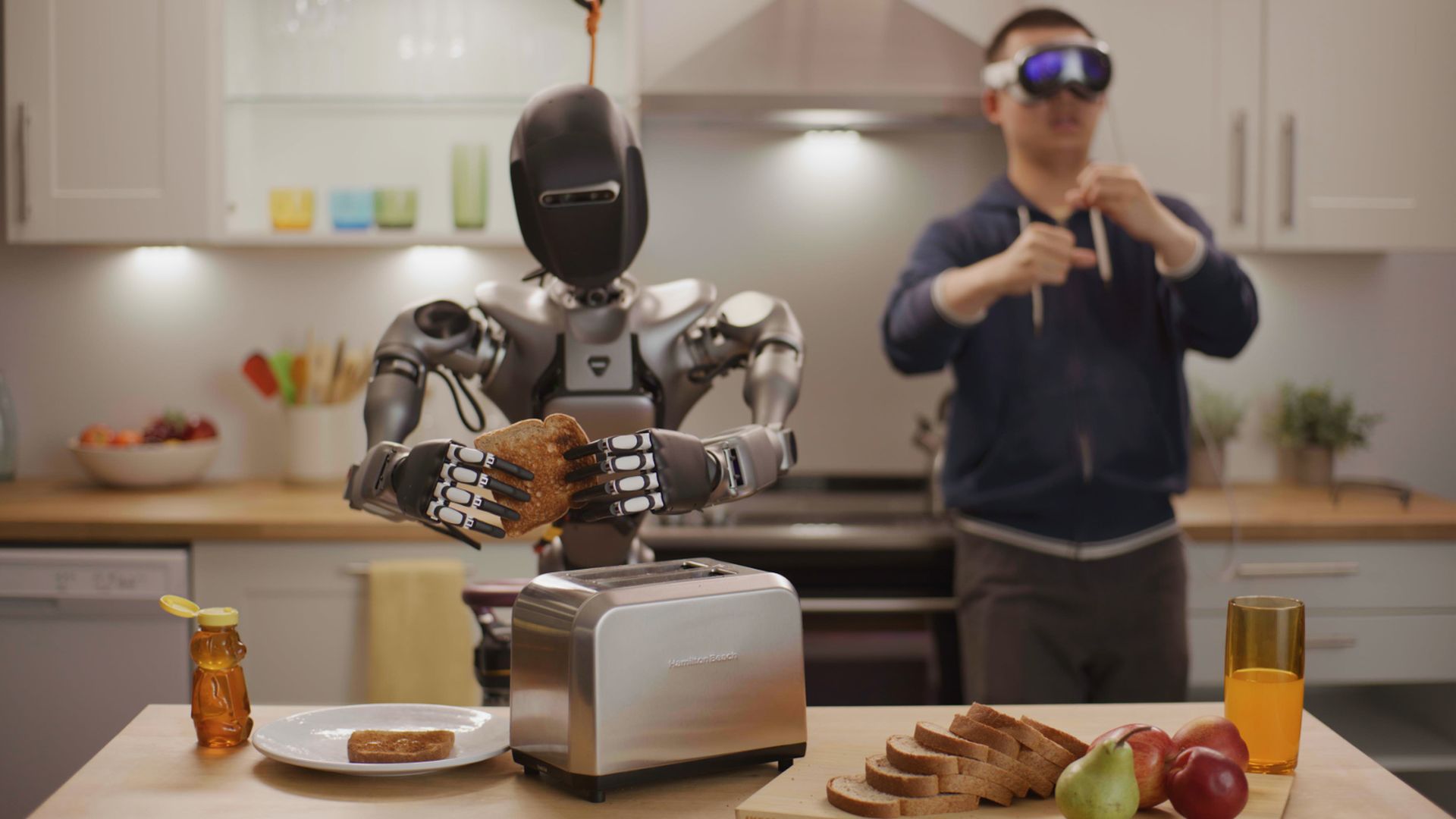 photo of a robot holding a piece of toast while a man standing behind him is acting like he's holding a piece of toast