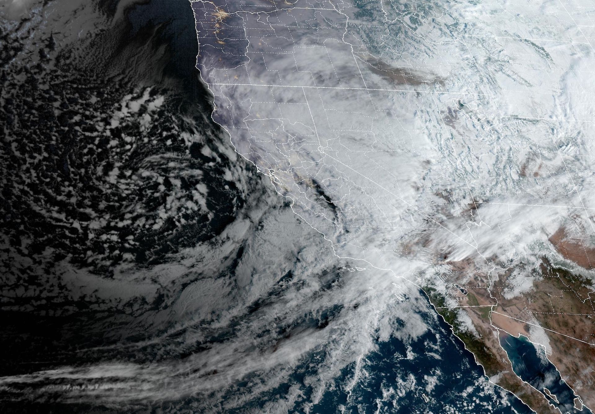 Satellite view showing the swirling storm off the California coast, pushing moisture inland.