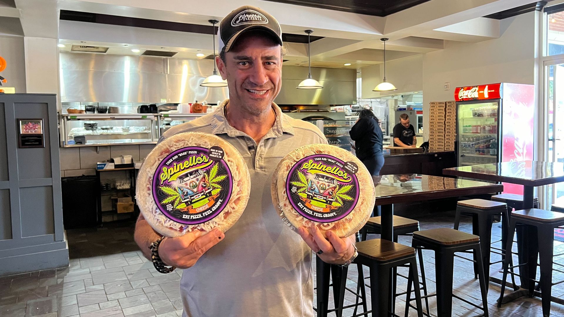 Mike holds two frozen pizzas
