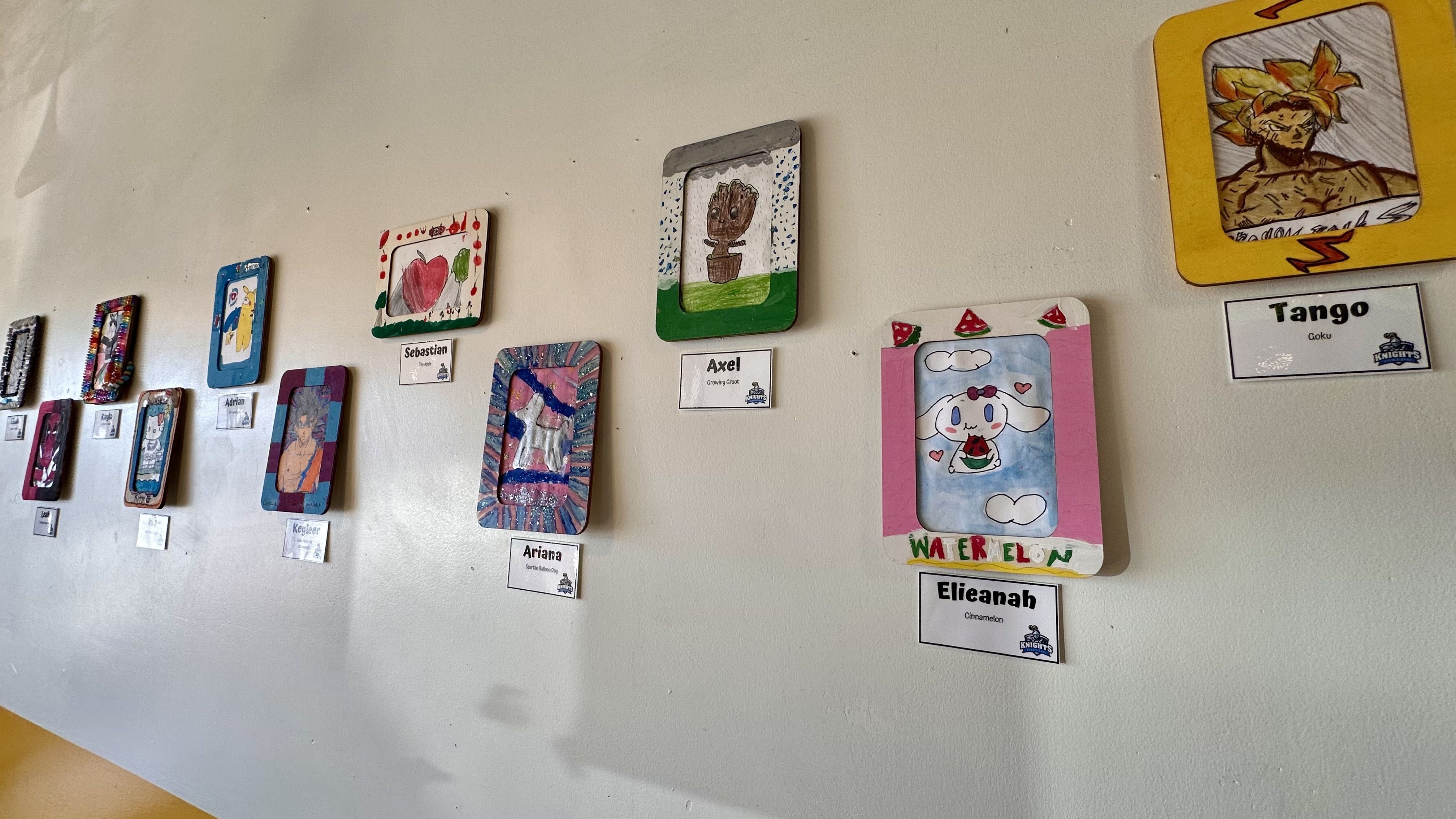 A photo of children's artwork on the wall