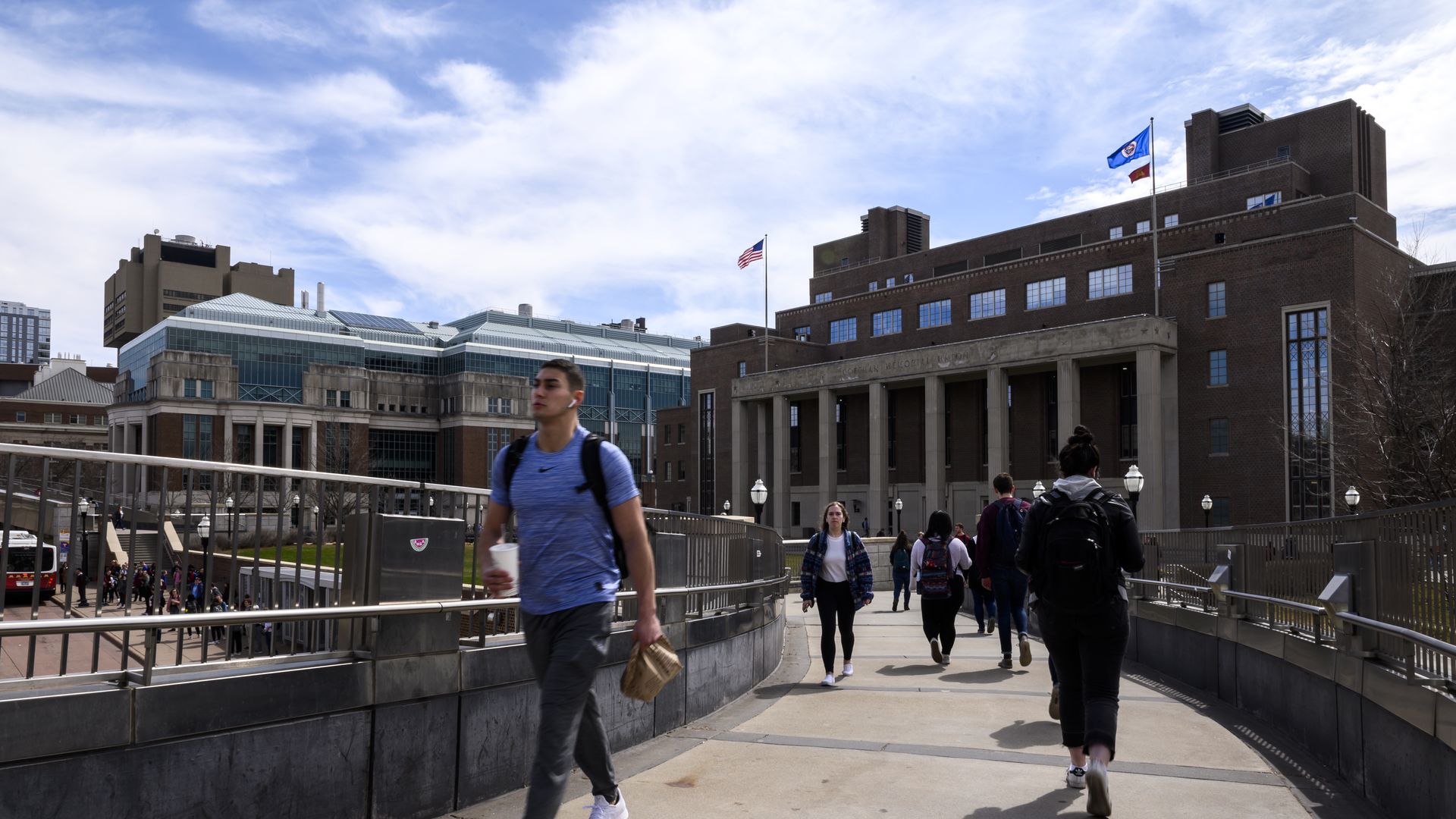 students walking at u of m campus on a bridge