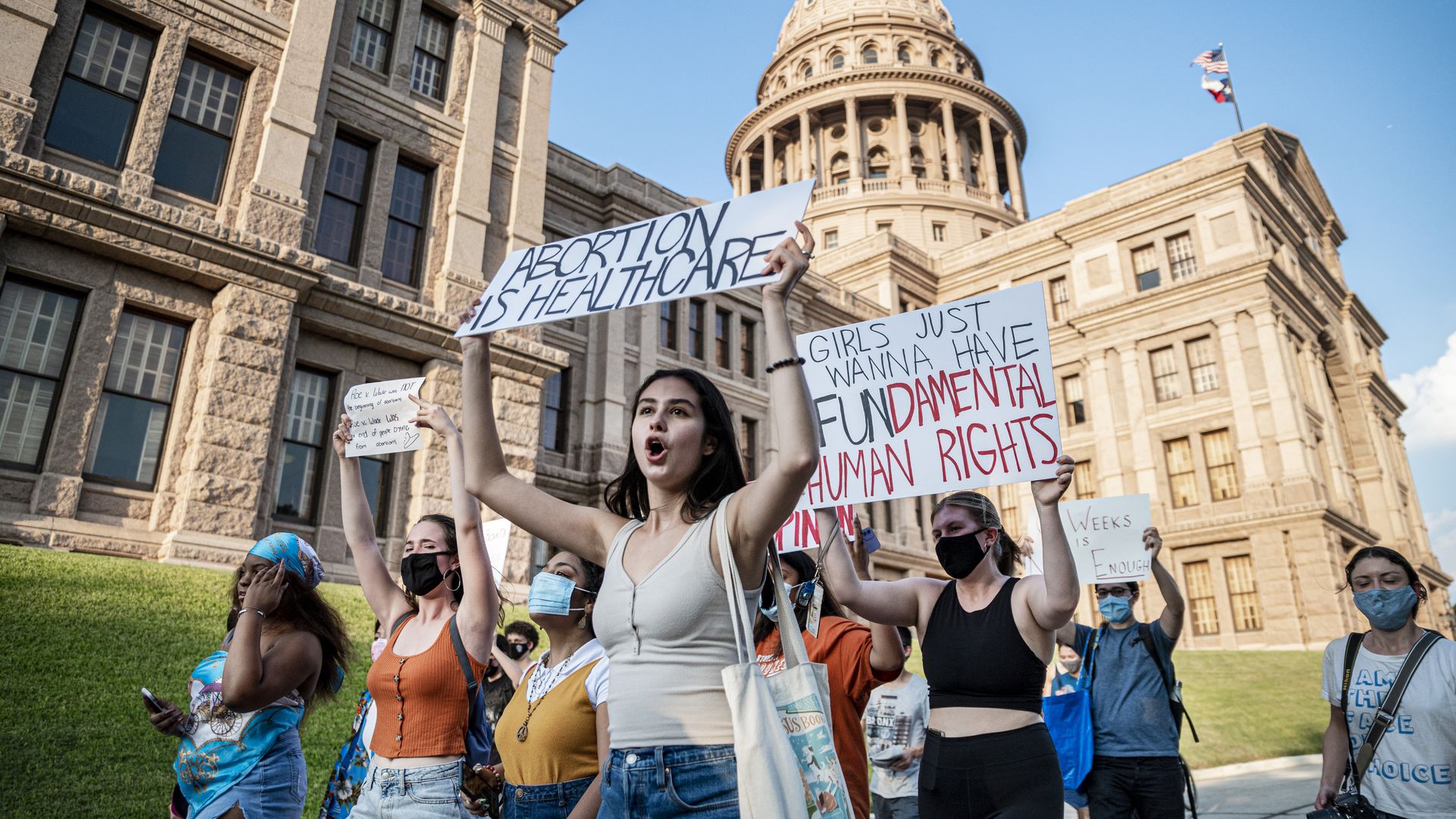 Photo of a group of demonstrators holding up signs that say "Abortion is healthcare!"