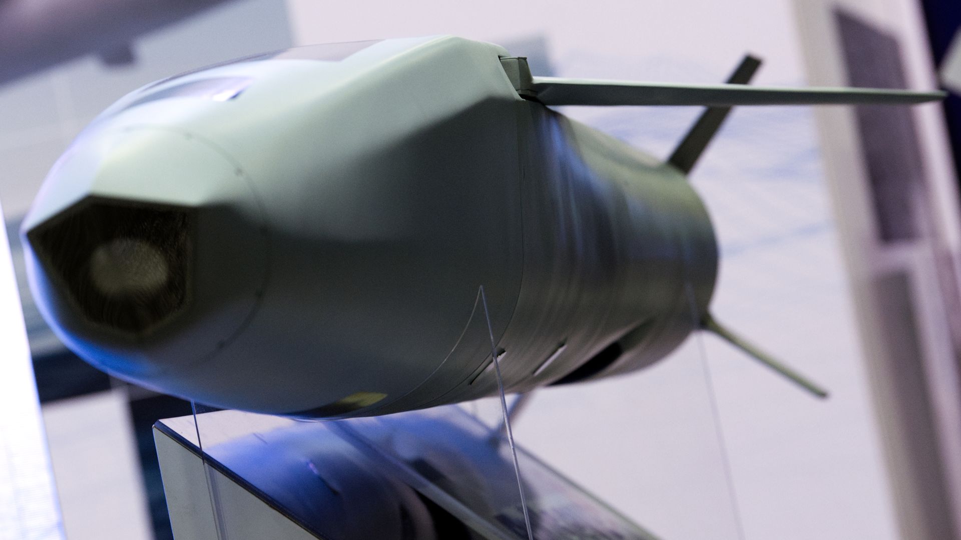 A model of a missile is mounted on a stand at a defense conference. It has several fins.