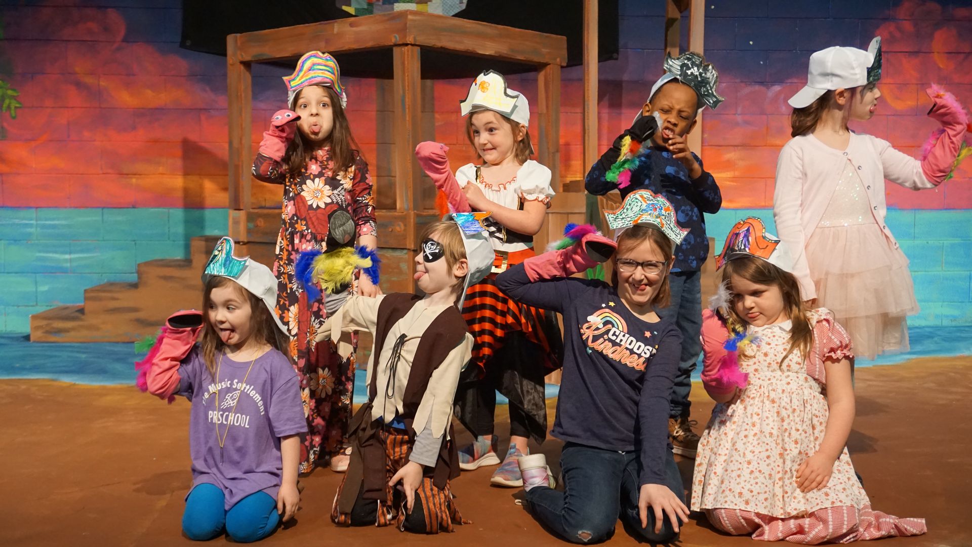 Children play with puppets on stage.